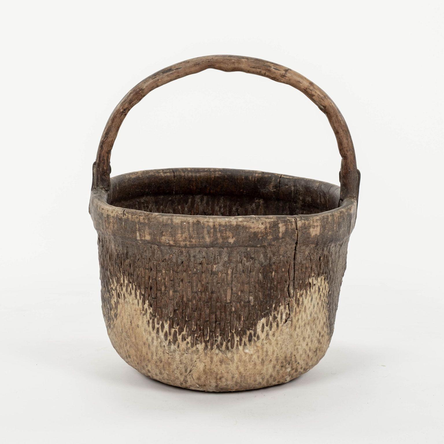 Mid-20th century woven Chinese rice basket with handle. Hand-woven willow with elm handle. Beautiful faded patina and texture from decades of wear. Three baskets available (see pictures). Baskets are sold individually and priced $1,400 each.

Note: