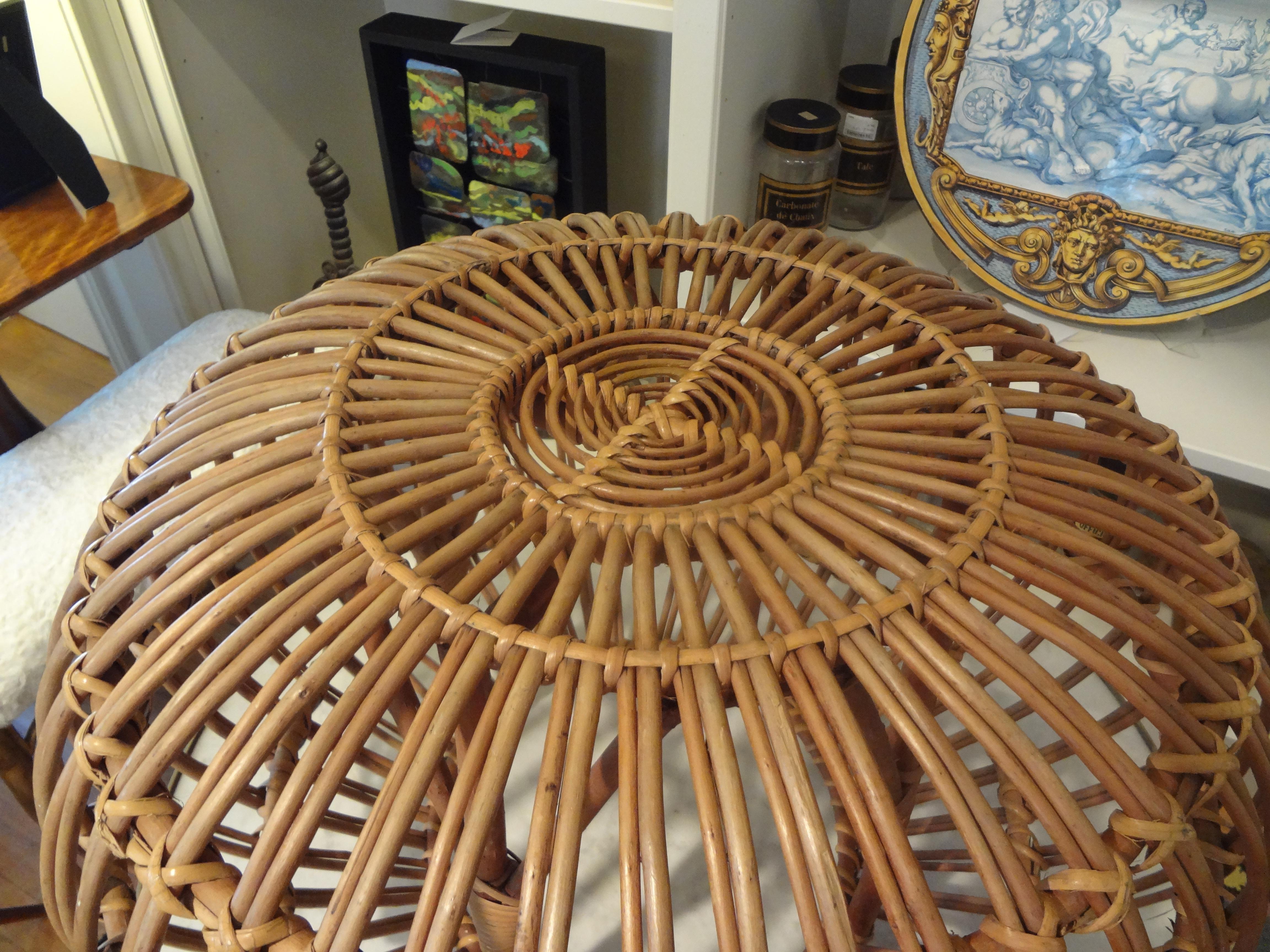 Mid-20th century woven rattan ottoman, pouf or stool designed by Italian designer Franco Albini. This versatile Hollywood Regency piece would make a great side table. This would work well in a variety of design settings.
