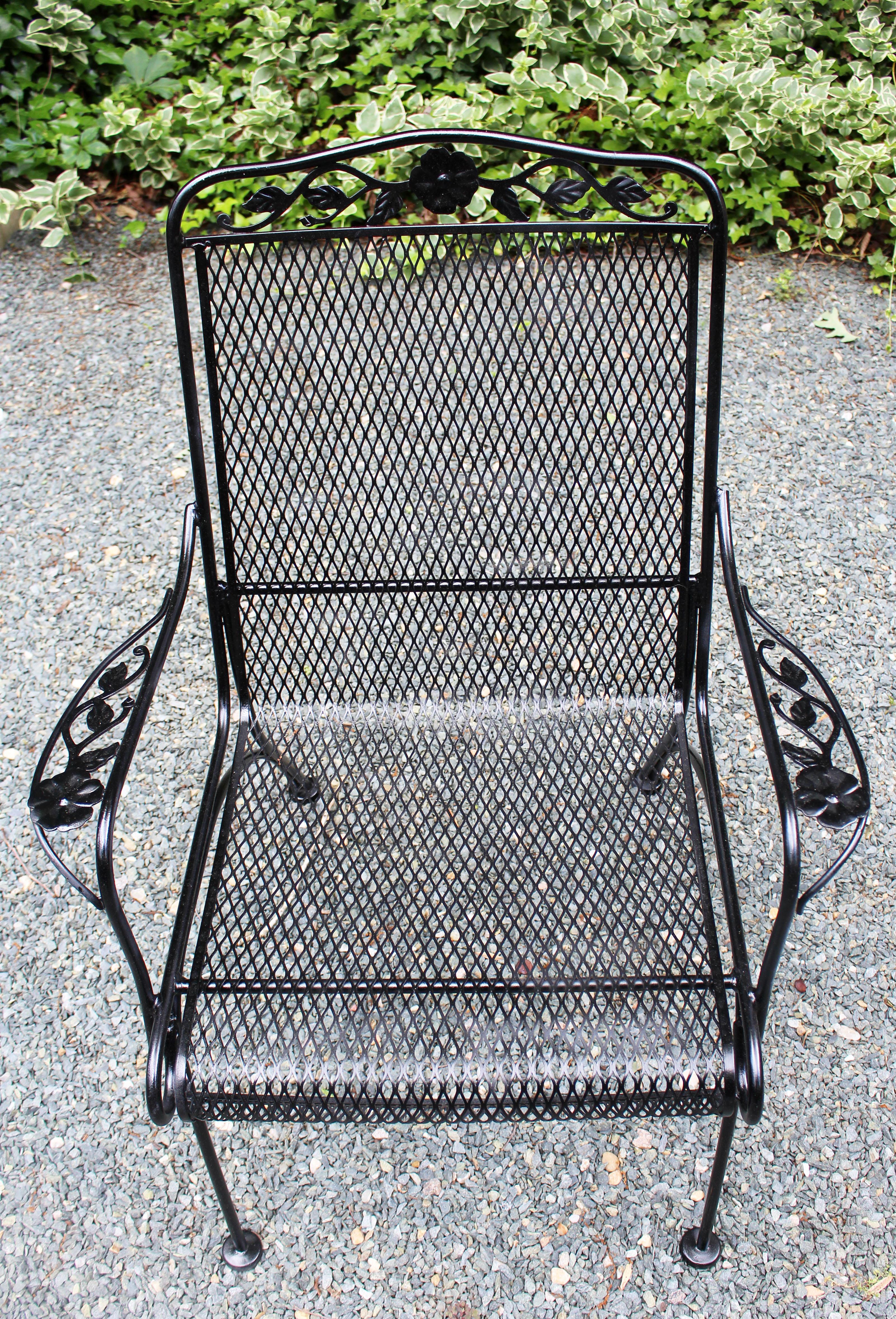 Wrought iron arm chair, mid-20th century, attributed to Russell Woodard. Daisy medallion with leaf tendrils on crest and arms. Rolled seat front. Sturdy, arched, outswept back legs. Repainted.
26