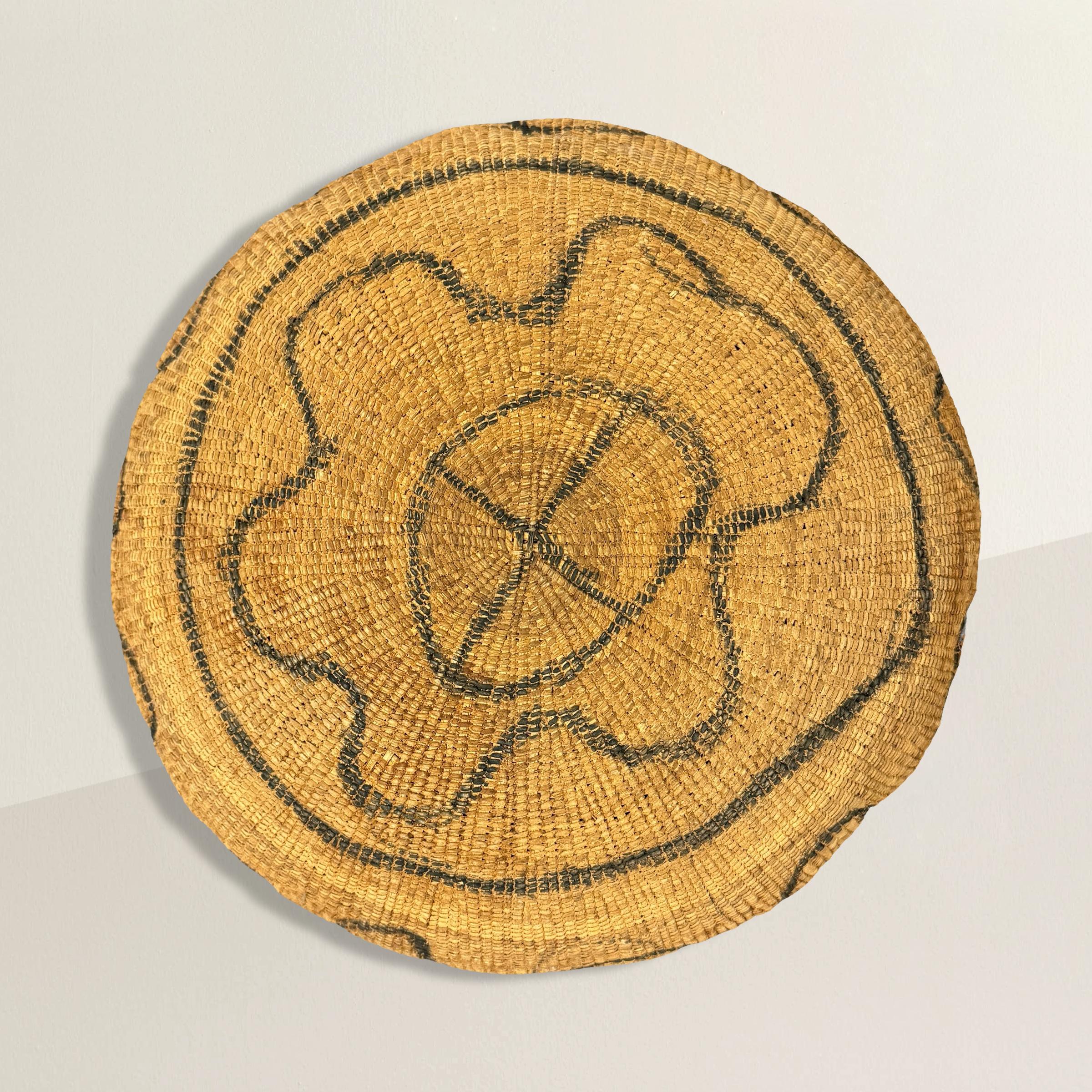 This impressive mid-20th century Yanomami gathering basket is a stunning example of indigenous craftsmanship. It features a large, woven form adorned with distinctive squiggle lines drawn in black ash, evocative of the Amazon river on which the