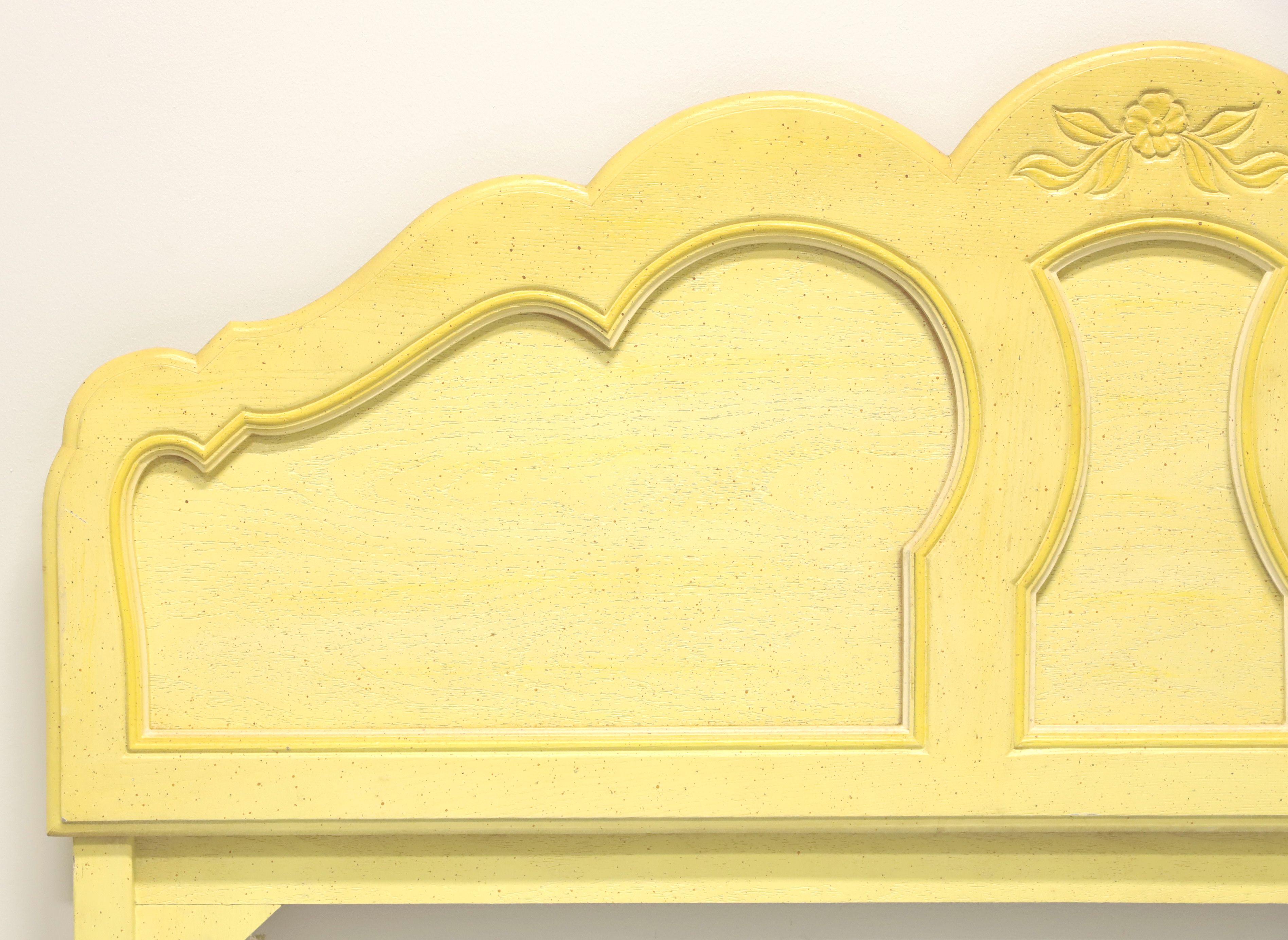 A French Country style full size headboard, unbranded. Solid hardwood with yellow painted finish. Features a scalloped arched top and decorative carvings with a carved flower to center of arch. Made in the USA, in the mid 20th Century.

Measures: