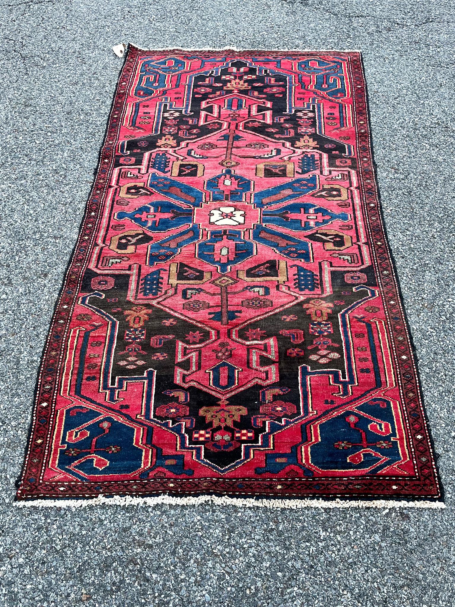 This beautiful Zanjan rug was handmade in the Mid-20th Century. It stands out for its rich, bright palette of red, blue, and black. The design features a large, central medallion composed of a floral, geometric motif.

Dimensions:
3' 5