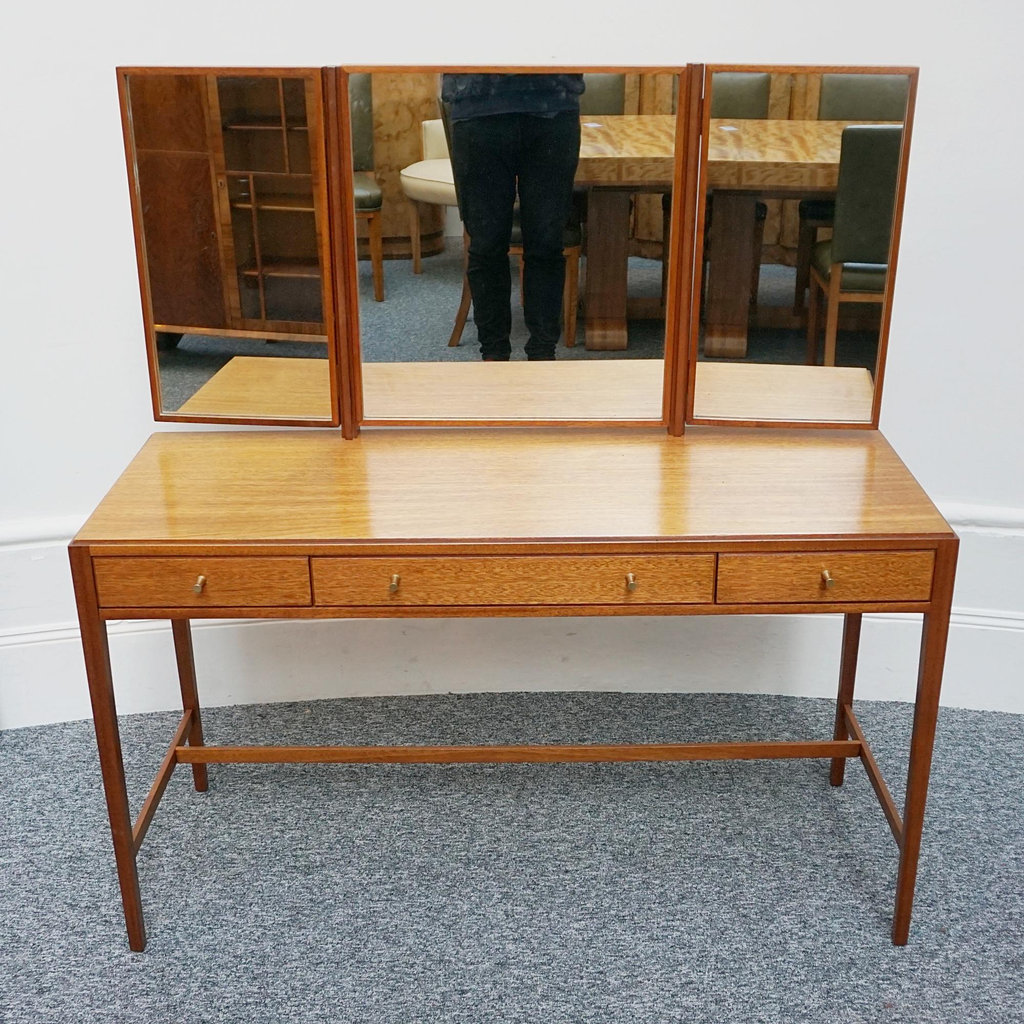 A Mid 20th century dressing table by designed by Neville Ward and Frank Austin for Loughborough Furniture, and retailed by Heal's of London. Figured olive walnut throughout with original metal handles. 

Dimensions: H 72cm with mirror 130cm W122cm D
