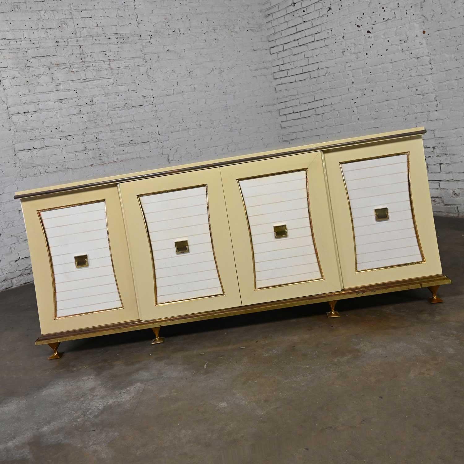 Gorgeous vintage Hollywood Regency Art Deco credenza or dresser by Renzo Rutili for Johnson Furniture comprised of an off-white painted top, ends & front of door frames; white gold embossed leather door panels; faux marbleized lacquered drawer
