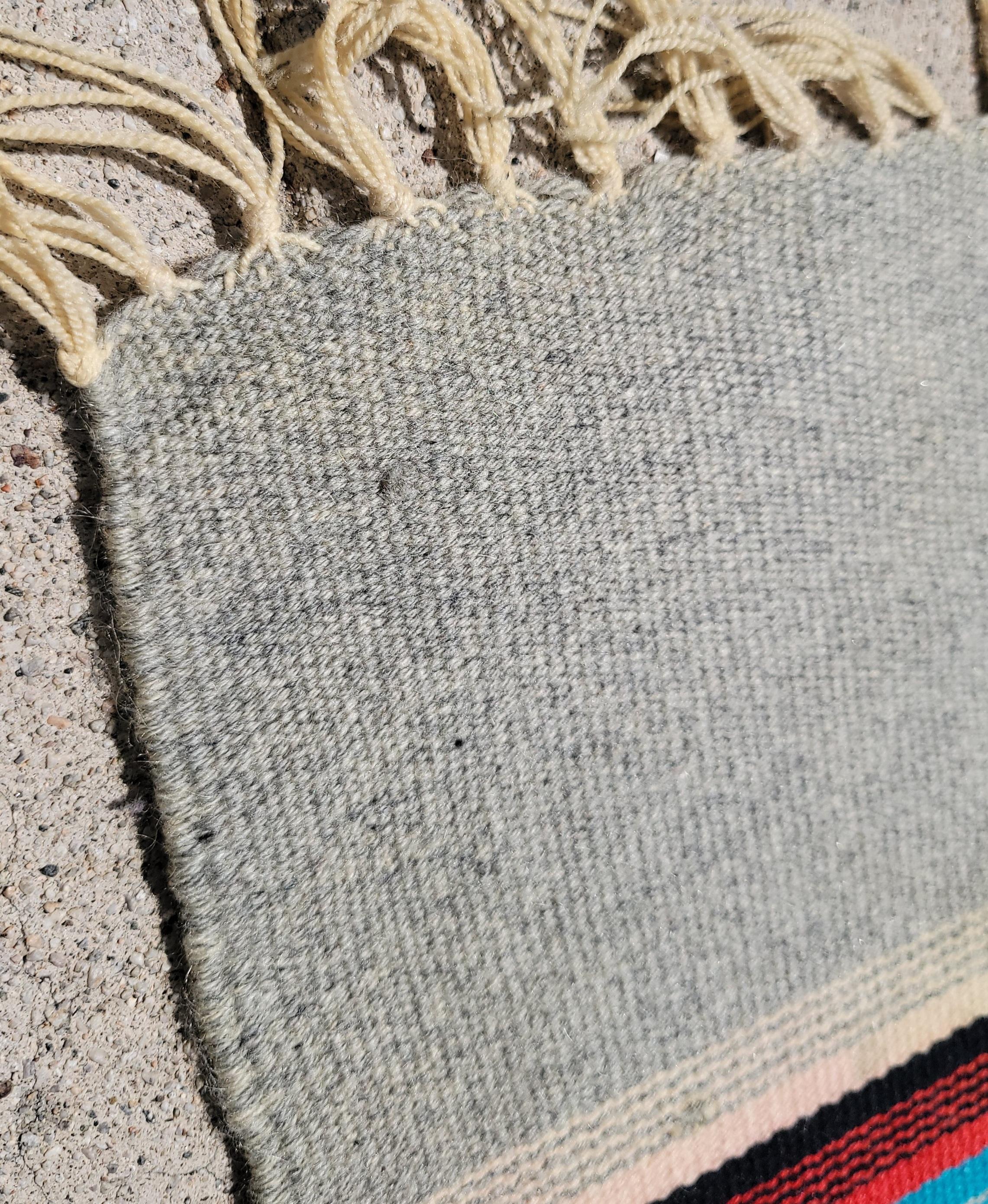 mid 20thc Wool Mexican Serape Rug with wonderful striped patterns. Within the striped pattern there are several colors that show how a neutral gray color may be utilized to show off bright blues and red in a subtle way. A great beautiful color