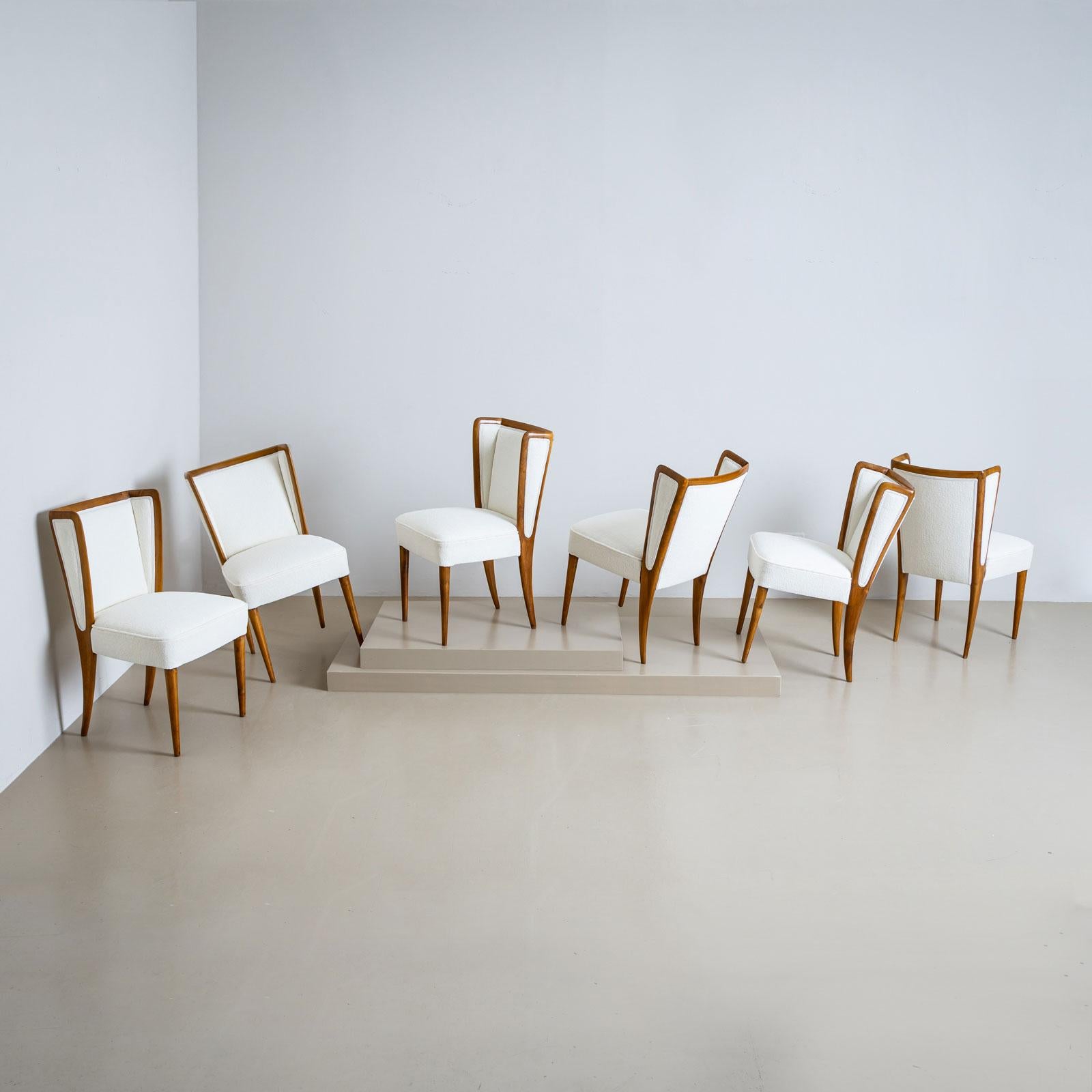 Un ensemble sophistiqué de six chaises de salle à manger avec des dossiers magnifiquement inclinés. Les sections latérales se fondent gracieusement dans les pieds arrière effilés, tandis que les pieds avant sont conçus dans une forme conique
