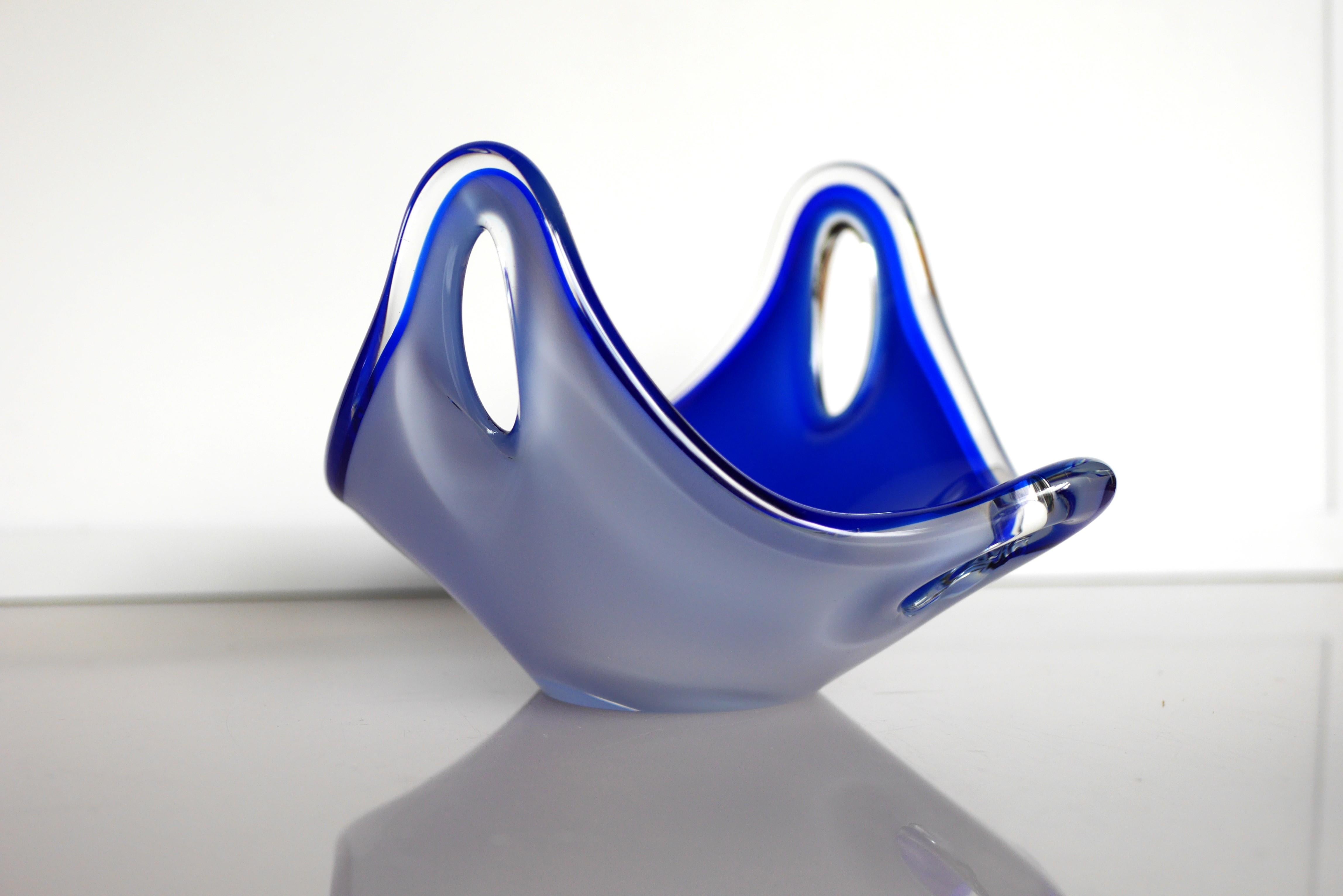 An incredible hand-blown vintage glass bowl, made and signed by the talented Paul Kedelv for Flygsfors, Sweden. The piece is very biomorphic, with arches with loops in them, and has an amazing almost iridescent blue color and on the outside it is