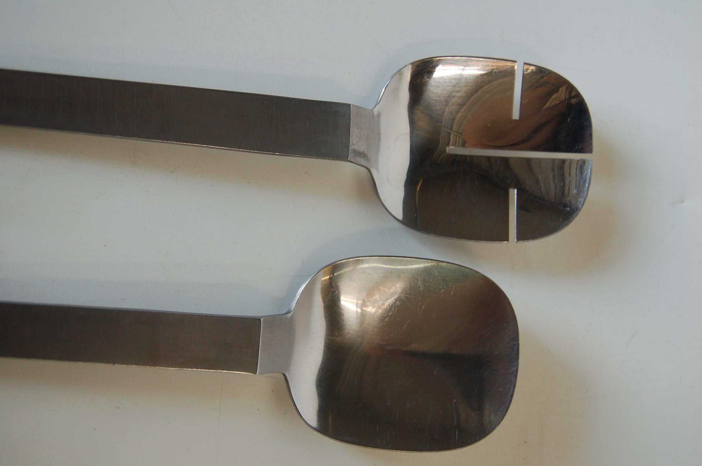 Mid-Century Modern criss cross cutout design in stainless steel. This salad serving utensils set is by Arthur Salm Amboss Austria.

Measures 10