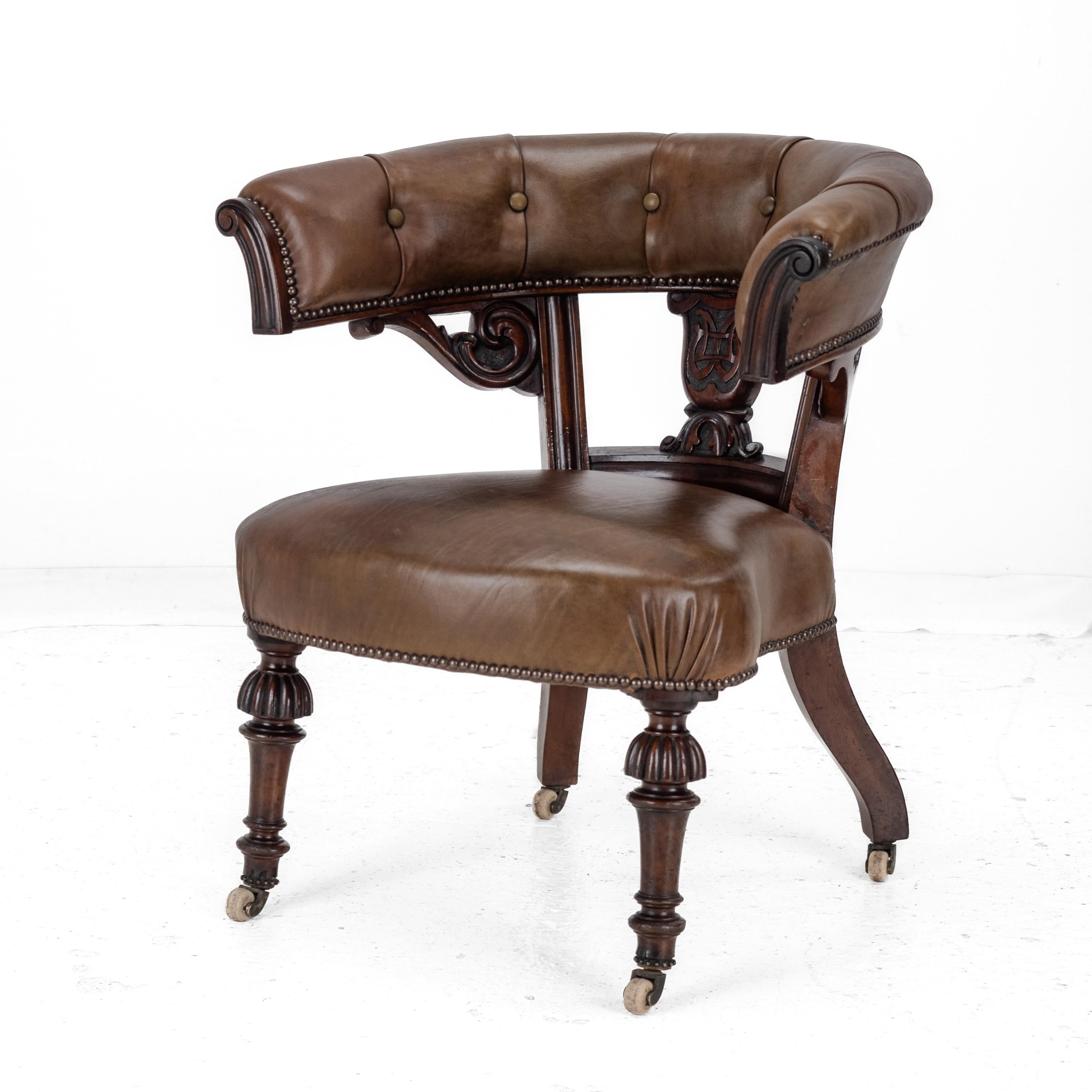 Fauteuil baignoire bibliothèque du milieu du 19e siècle, en acajou, avec cadre et rembourrage en cuir, vers 1850. Ce beau fauteuil à structure en acajou massif est doté d'un accoudoir continu recouvert de cuir teinté à la main avec des terminaisons