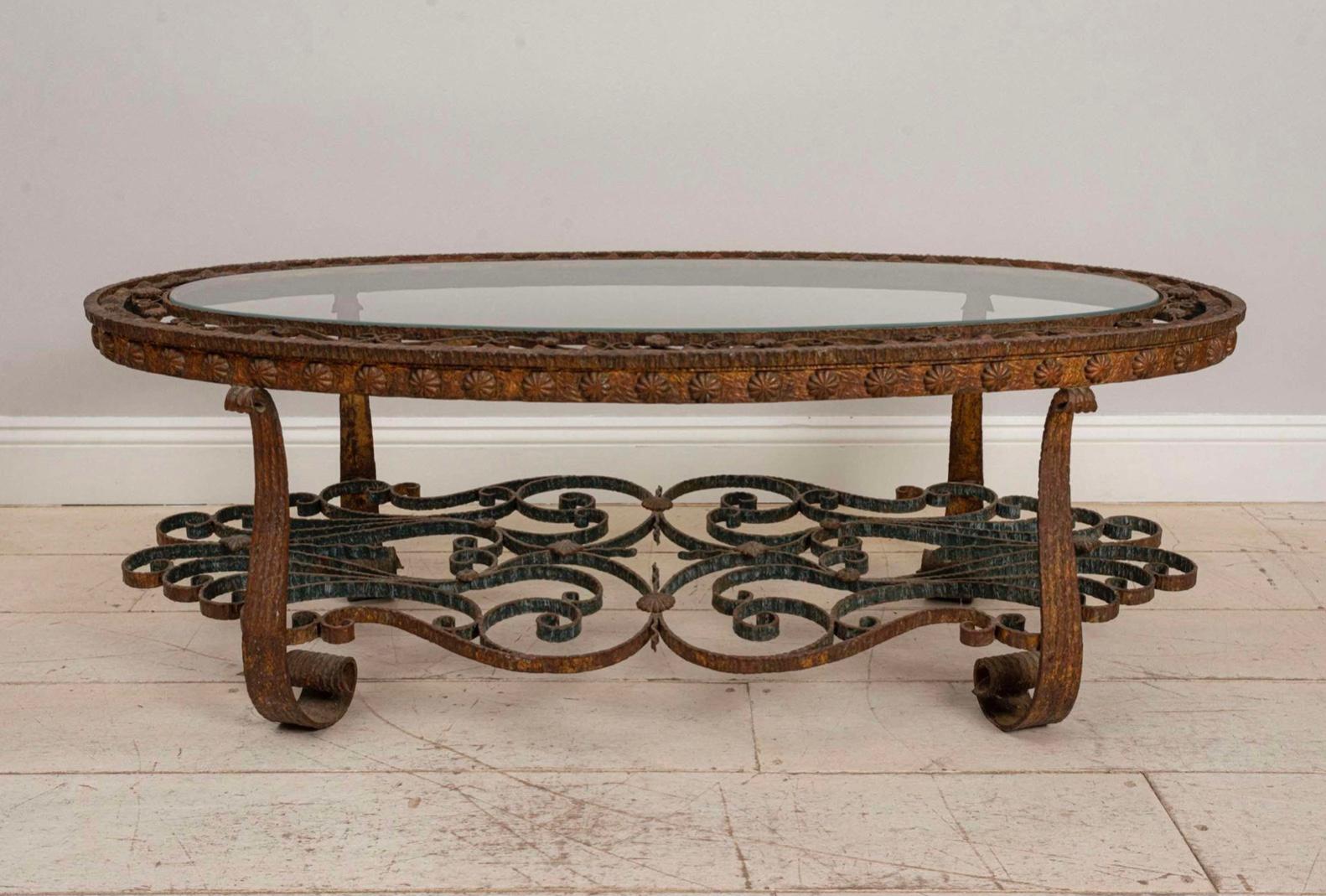 Cette table basse de forme ovale est dotée d'un plateau en verre renforcé entouré de fer forgé peint décoratif et d'un plateau utile en dessous.
Une pièce solide et utile qui s'intègre et fonctionne bien dans un intérieur contemporain ou