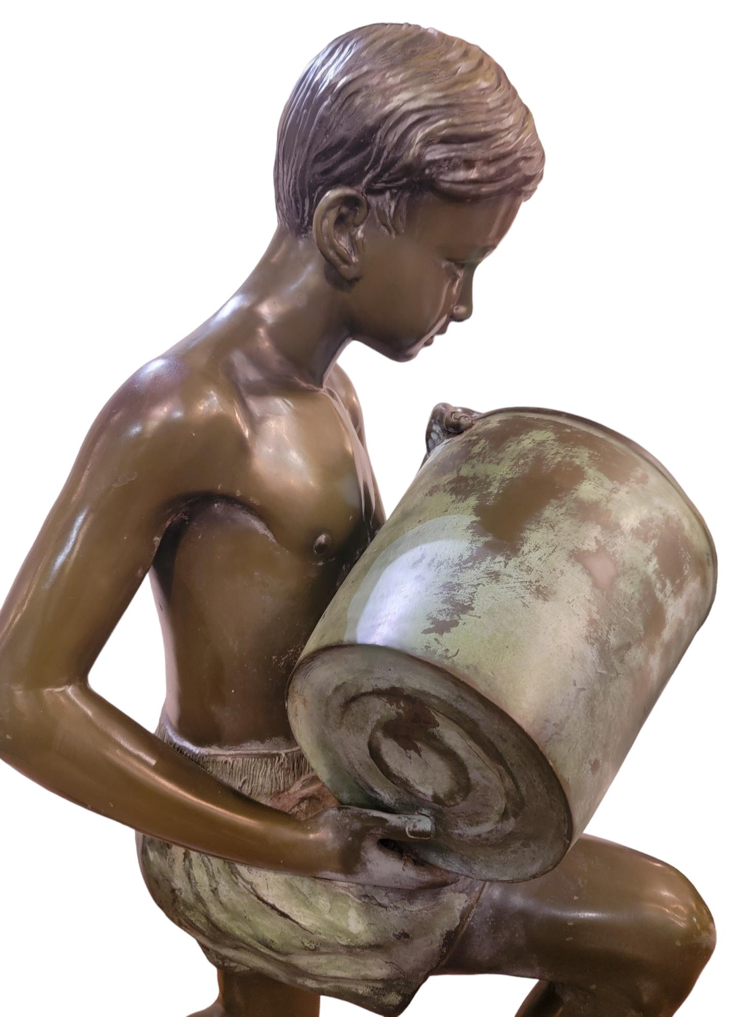 1940-50s kneeling bronze boy sculpture of boy holding a bucket. This sculpture Has amazing color and patina to the boy. 
Strong life sized sculpture. 