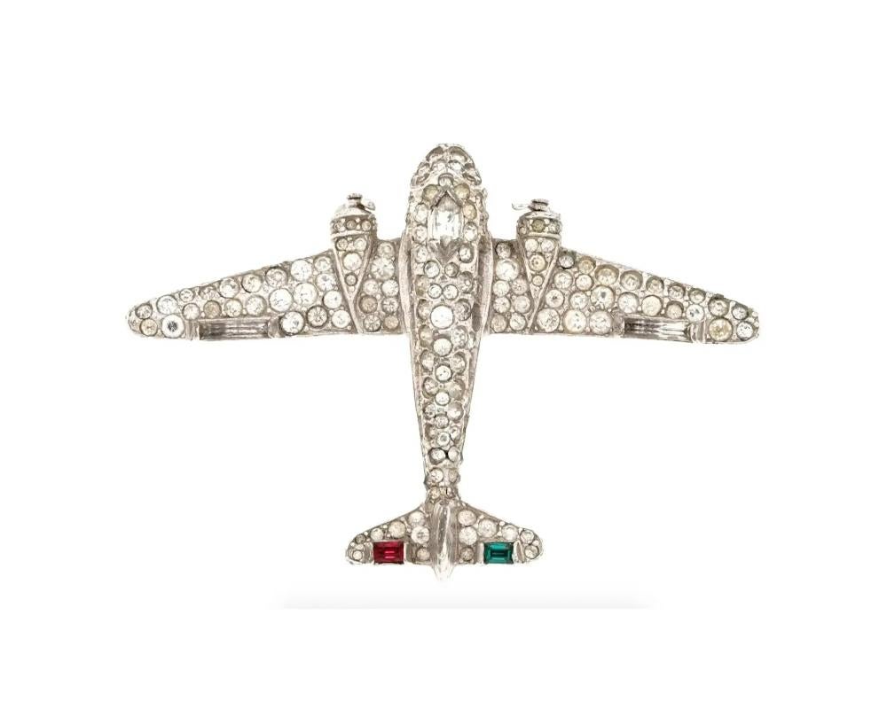 A mid 20th-century silver-tone brooch by Trifari. The piece represents an airplane fully embellished with rhinestones and faceted color glass stones. Hallmark Trifari is on the backside. Collectible Stylish Lapel Jewelry For Women.

Dimensions: