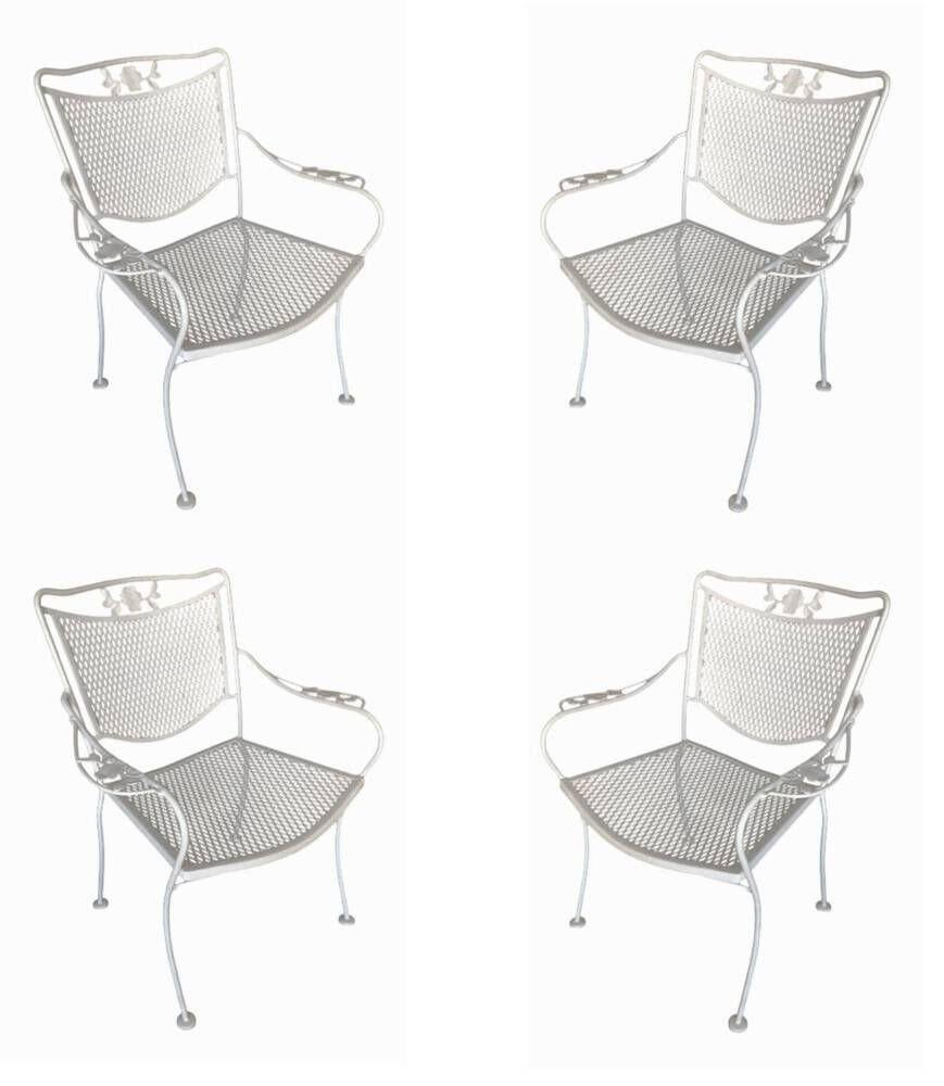 Set of 4 Mid-Century outdoor mesh scrolling armchairs and matching table by the Woodard furniture company in Owosso, Michigan. These Steel and iron chairs feature a decorative scrolling floral motif along the backrest and arms with wrought iron