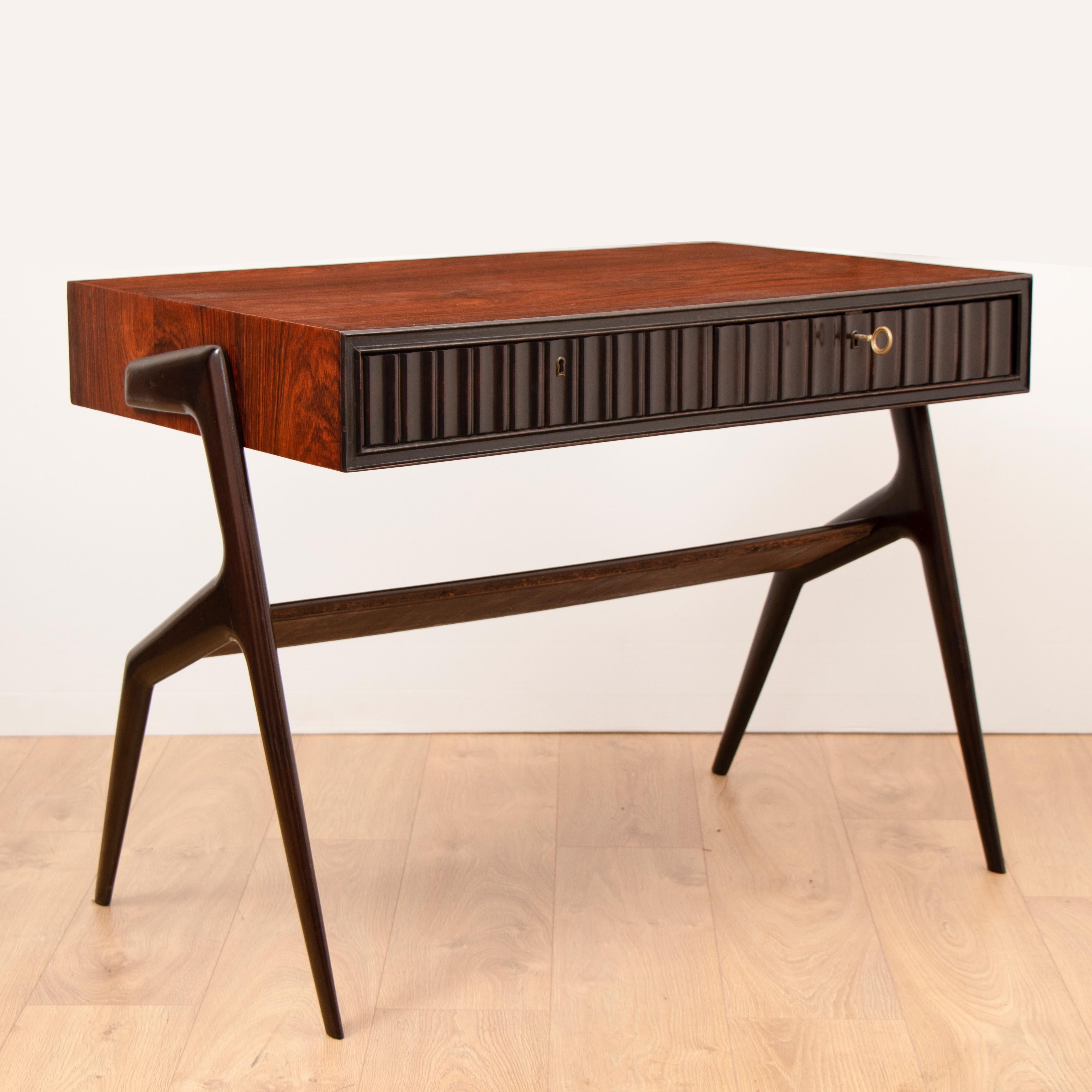 A rare 1950s two-drawer vintage Brazilian rosewood and beech writing desk in the style of Ico Parisi. The feature, sculptured, legs have a deep dark brown ebonised stain which contrasts against the Rosewood of the desk. A central angled display