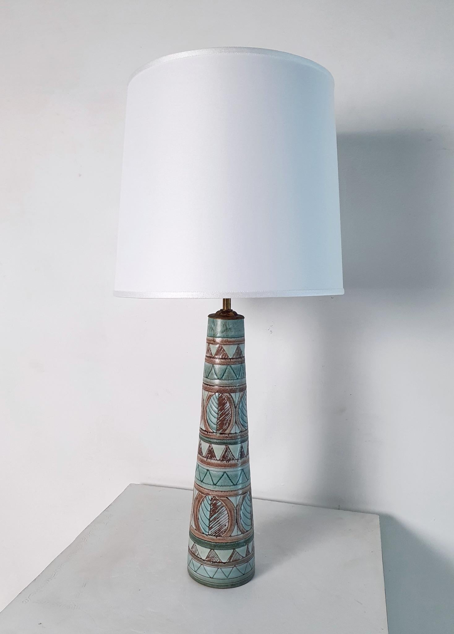 Indulge your inner collector with this exquisite mid century lamp by the renowned Swedish ceramicist Irma Yourstone. With its unique design and exceptional quality, this lamp is a true gem that's not often found. Feast your eyes on the flawless