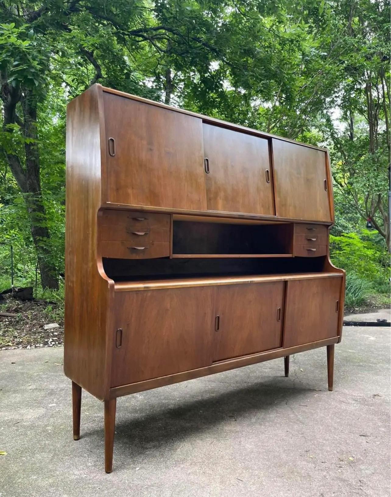 This is a very unique hard to find 1950s walnut Highboard Sideboard. The piece was made in Denmark and has a great lines and is very stylish.