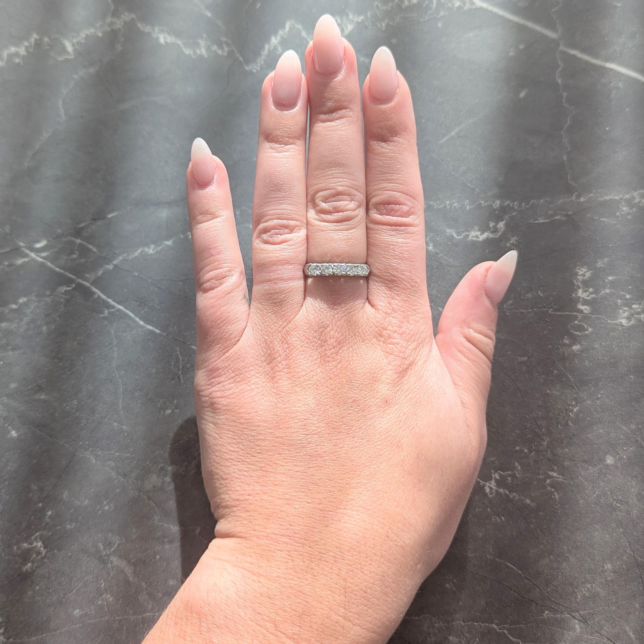 Mit fünf runden Diamanten im Brillantschliff in Zackenfassung auf der Vorderseite
Mit einem Gesamtgewicht von etwa 0,75 Karat
Farbe G/H mit Klarheit VS
Mit einem Profil mit Fischschwanzmotiv
Gestempelt für Platin
Circa: 1950er Jahre
Ringgröße: 7 1/2