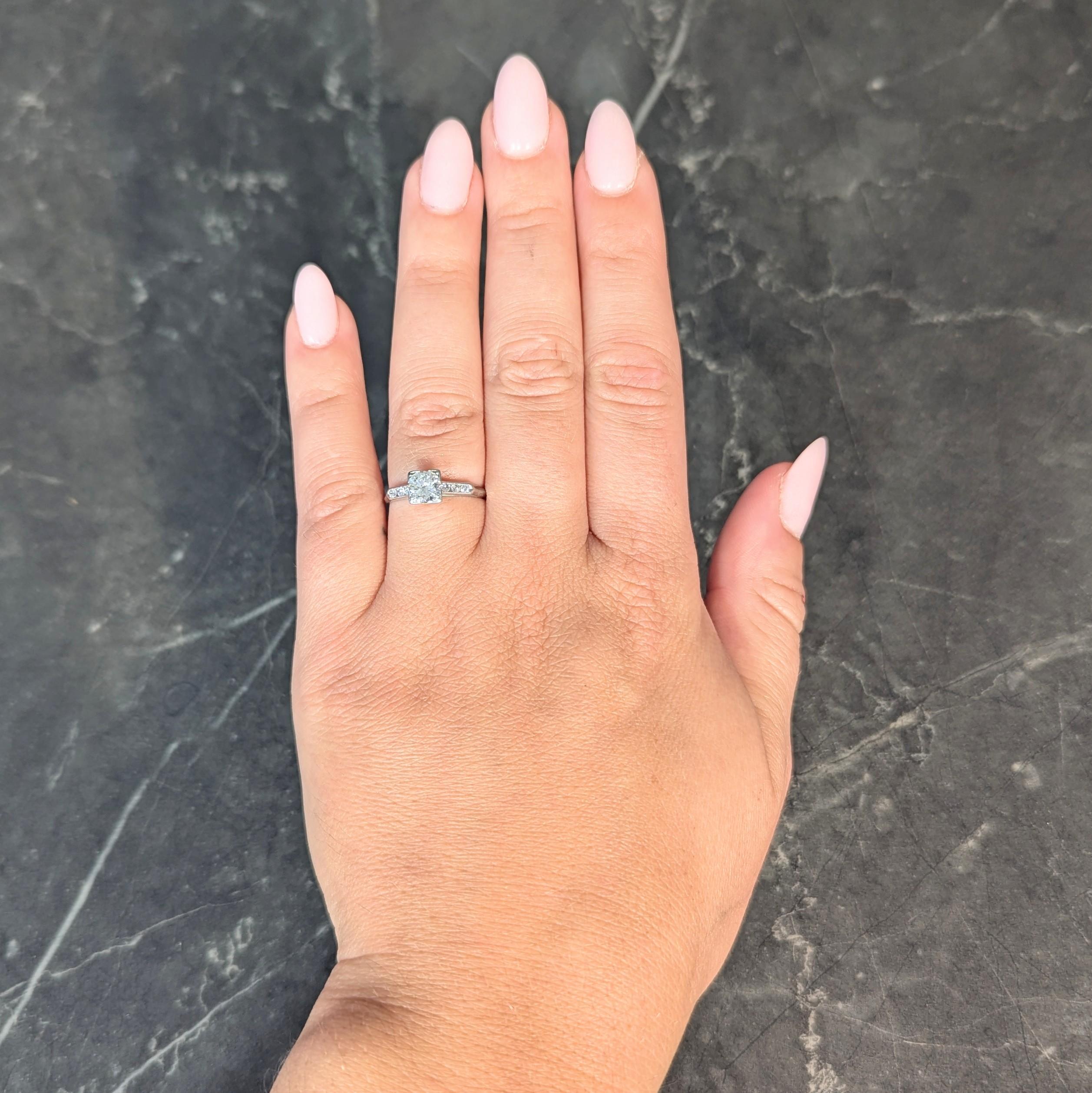 Centering a transitional cut diamond weighing approximately 0.72 carat - J color with VS1 clarity
Set by tri-beads in a stylized square form head flanked by pointed cathedral shoulders
Accented by bead set transitional cut diamonds 
Weighing