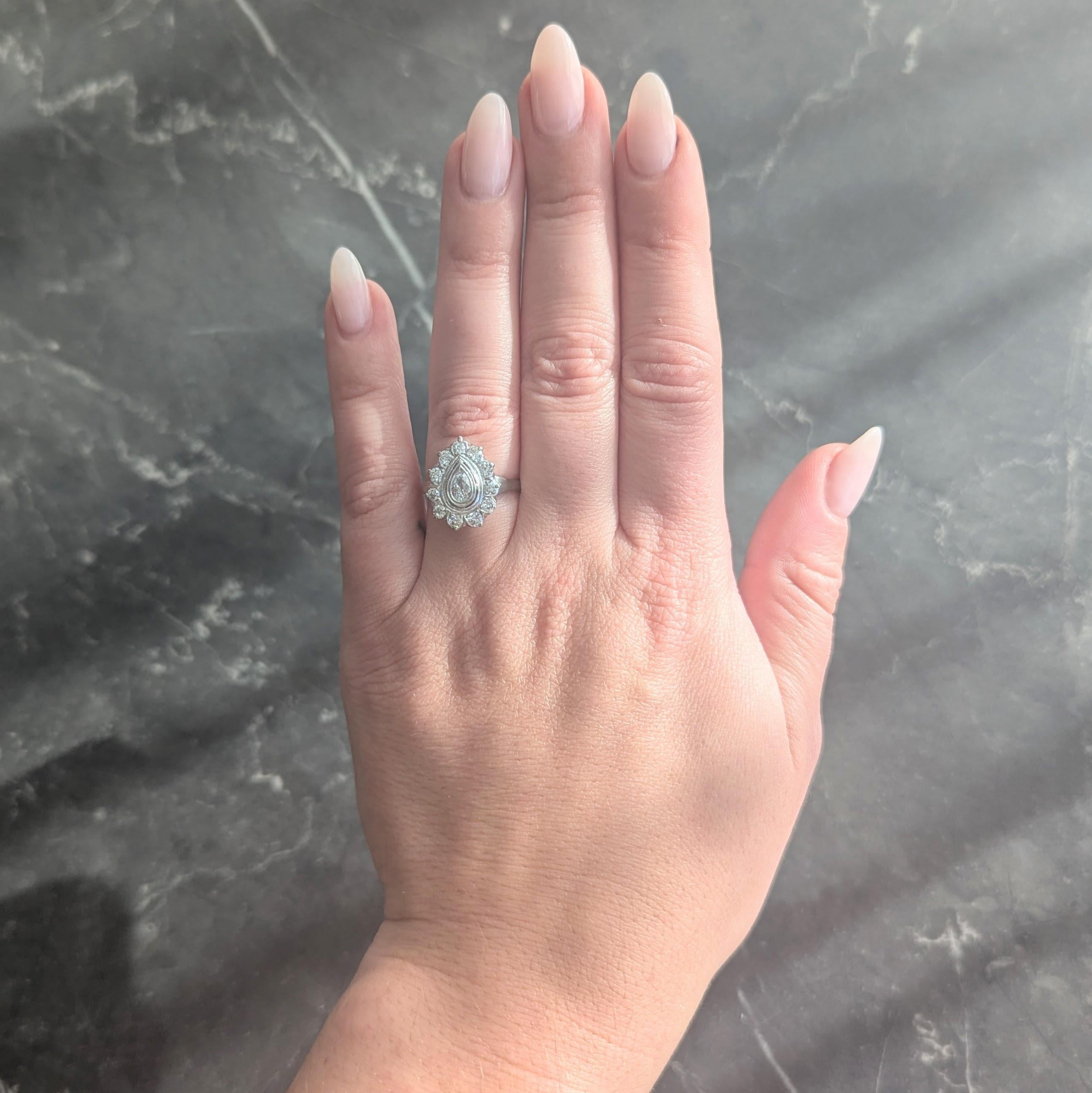 Al centro un diamante taglio pera del peso di circa 0,20 carati - colore G con purezza VS2
Lunetta incastonata con un'aureola fluttuante traforata di diamanti taglio vecchio europeo
Pesa circa 0.68 carati in totale
Colore G/H con purezza da VS2 a