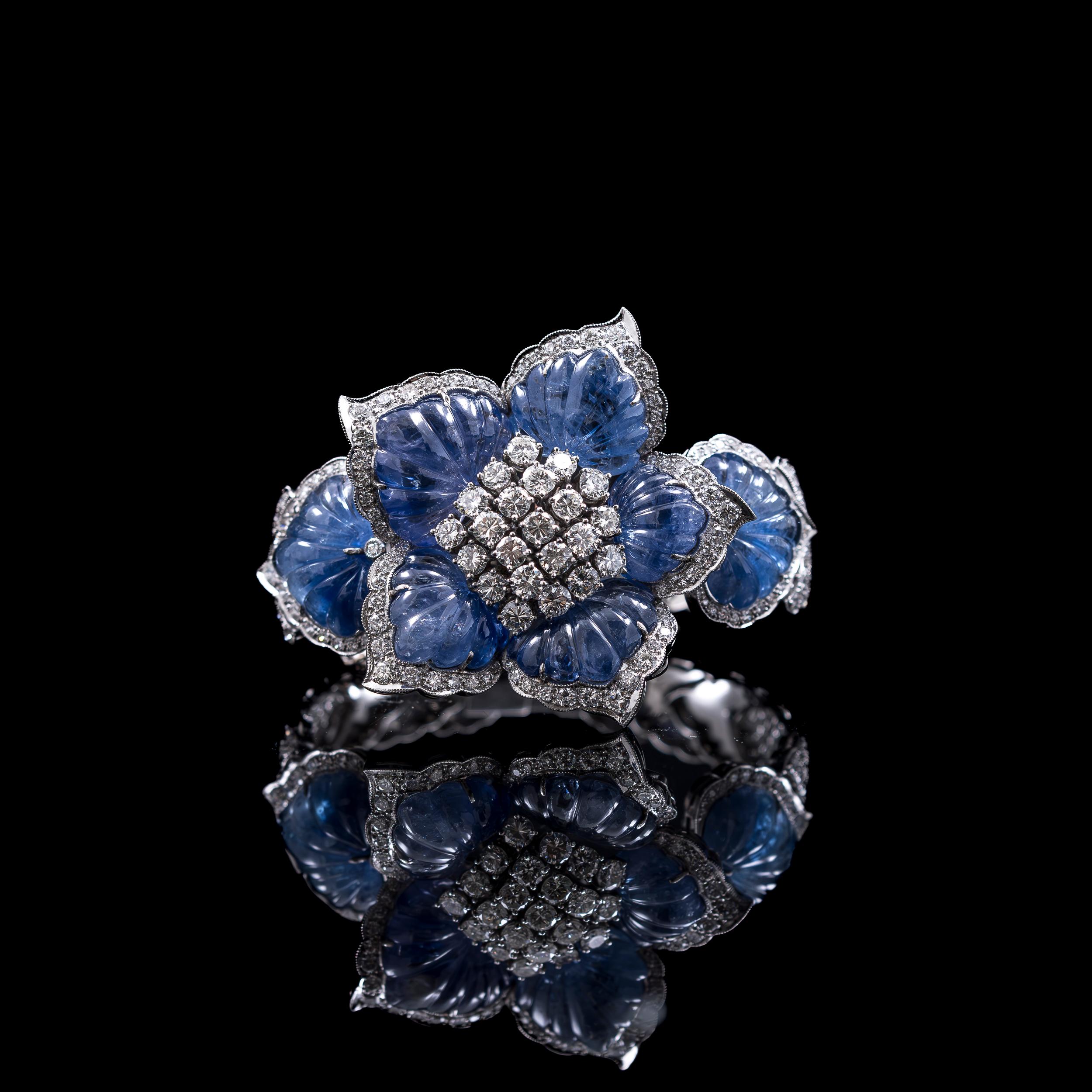 Bracelet fleur en platine de 100 carats de saphir sculpté à changement de couleur et de 11 carats de diamant rond de taille brillant, années 1950/1960.

Au cœur de cette pièce envoûtante se trouve un motif central en forme de tête de fleur, orné