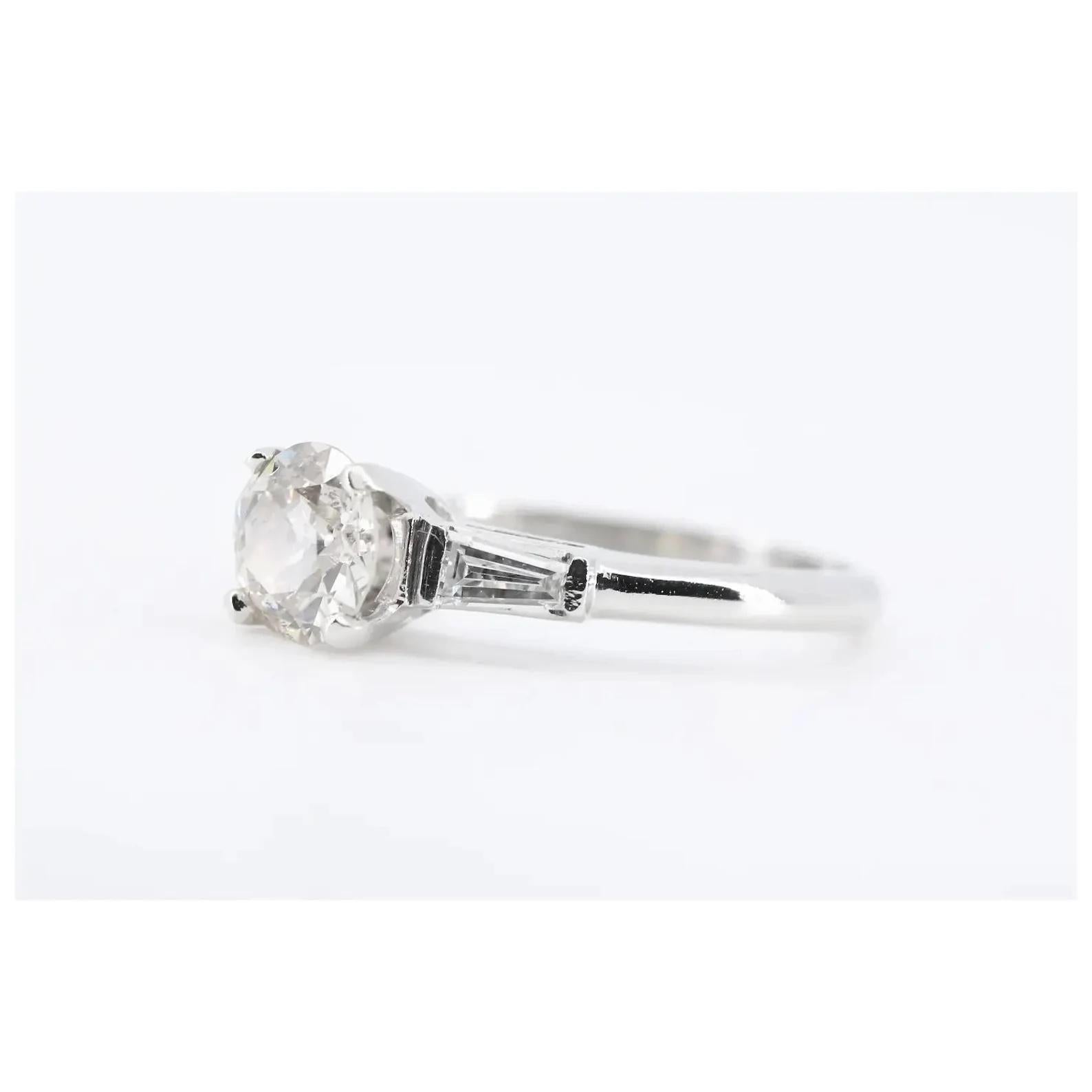 A mid century vintage platinum, and diamond engagement ring.

Centered by a 0.83 carat old European cut diamond of J color and SI1 clarity.

Framing the center diamond are two 0.20ctw tapered baguette cut diamonds of G color, VS clarity.

Mounted in