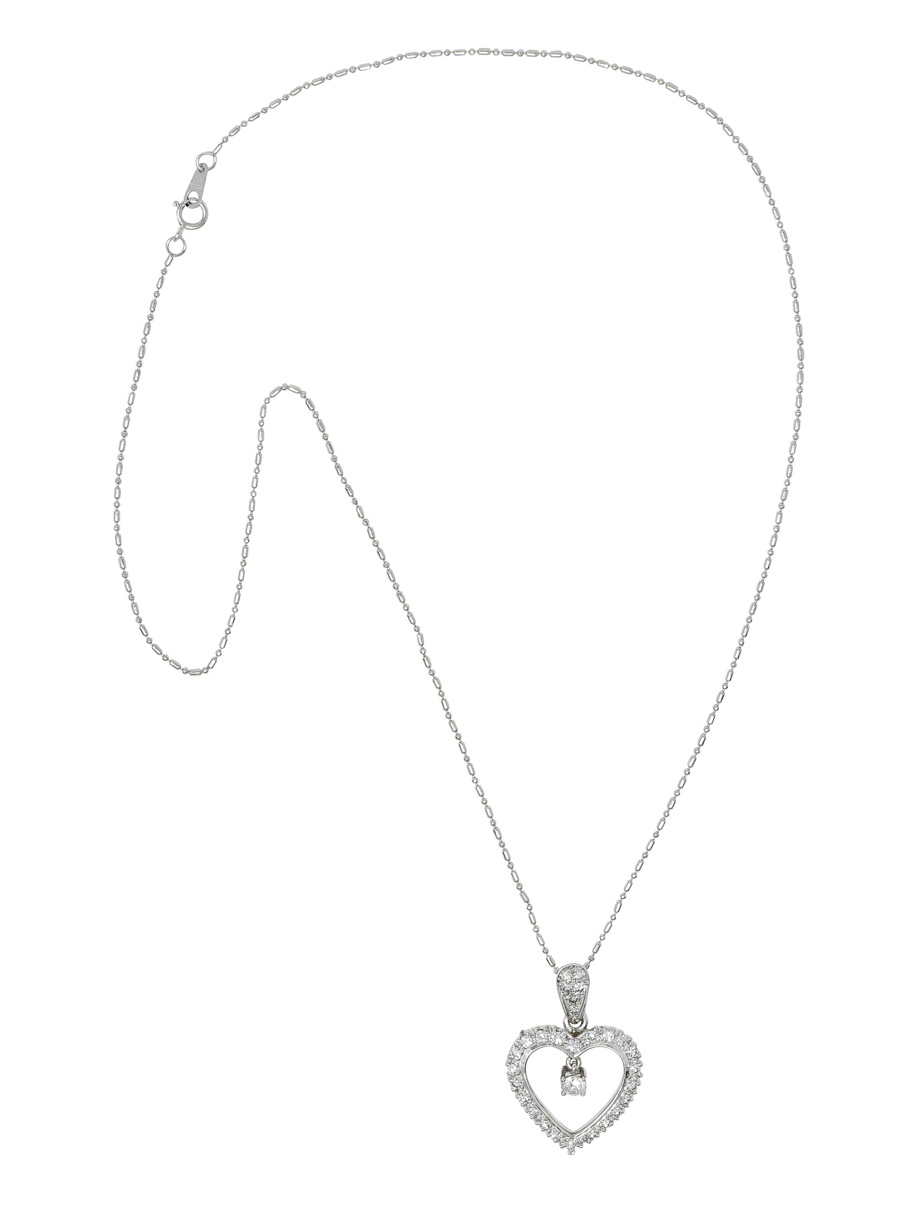 Designed as a 1.0 mm bead chain suspending a heart-shaped pendant from pear-shaped bale 
Centering an old European cut diamond weighing approximately 0.24 carat 
G color with VS2 clarity - prong set in basket as articulating drop 
With additional