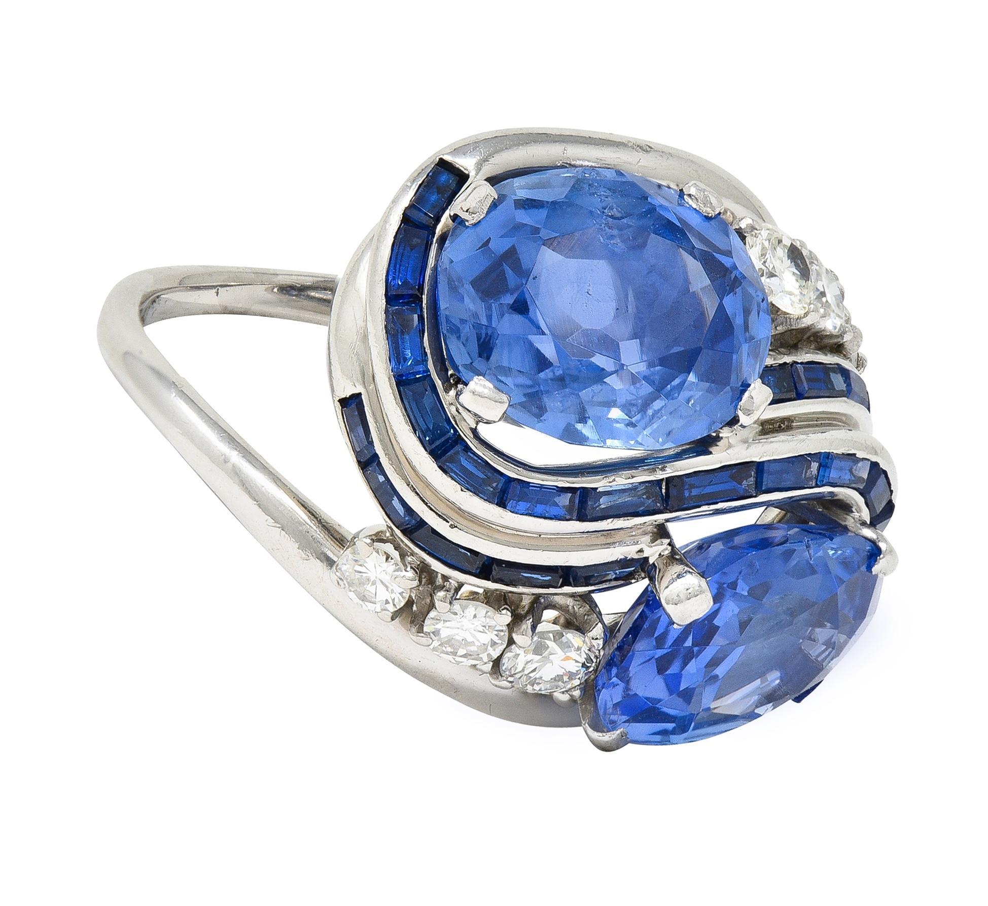 Featuring two oval-shaped mixed-cut sapphires weighing approximately 9.45 carats total - transparent medium blue 
Natural Sri Lankan in origin with no indications of heat treatments - prong set east to west and juxtaposed
Featuring swirling rows of