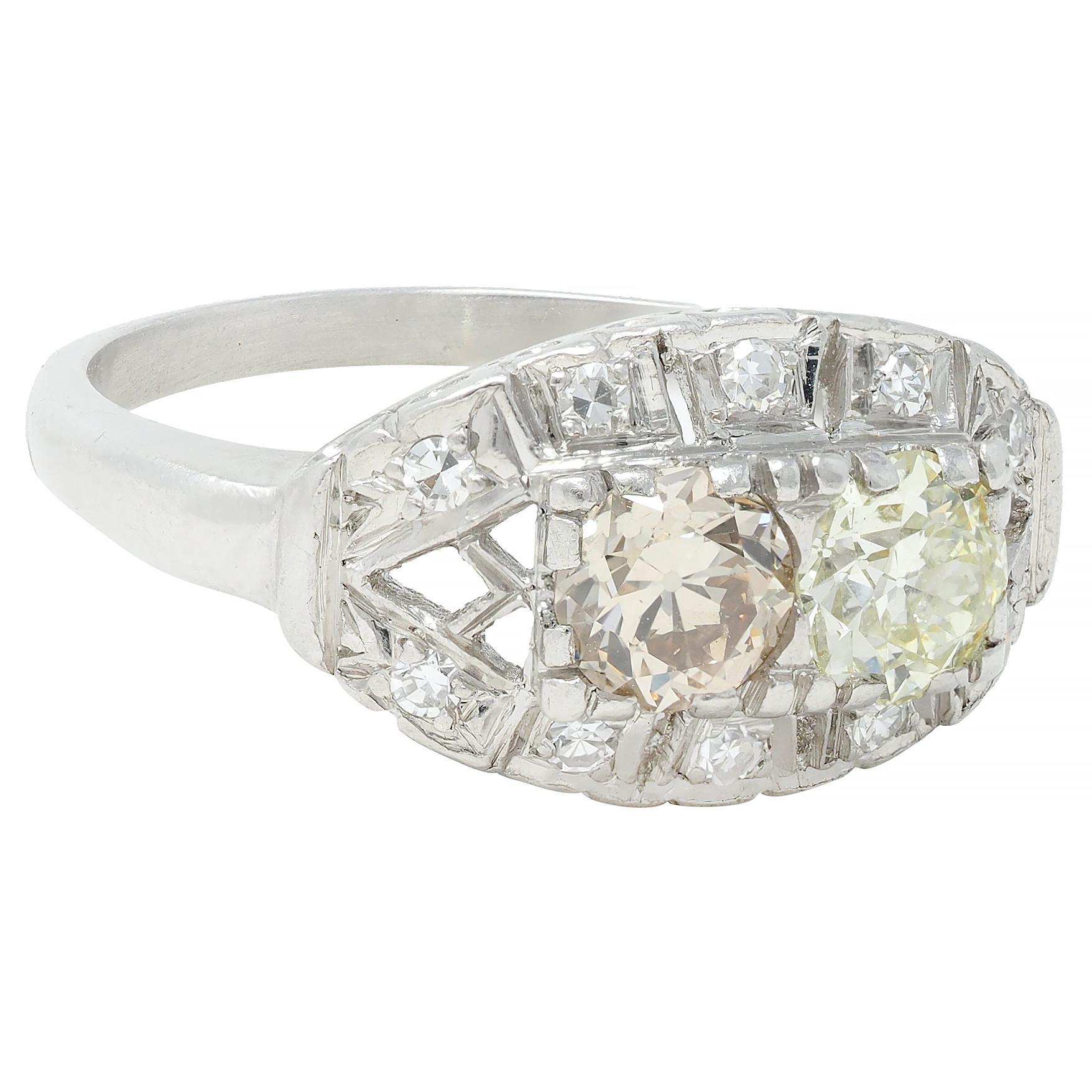 Centering two old European cut diamonds weighing approximately 0.87 carat total with VS2 clarity
One diamond is faint orange-yellow, and the other is faint greenish-yellow in color
Set with tri-split prongs east to west with a pierced