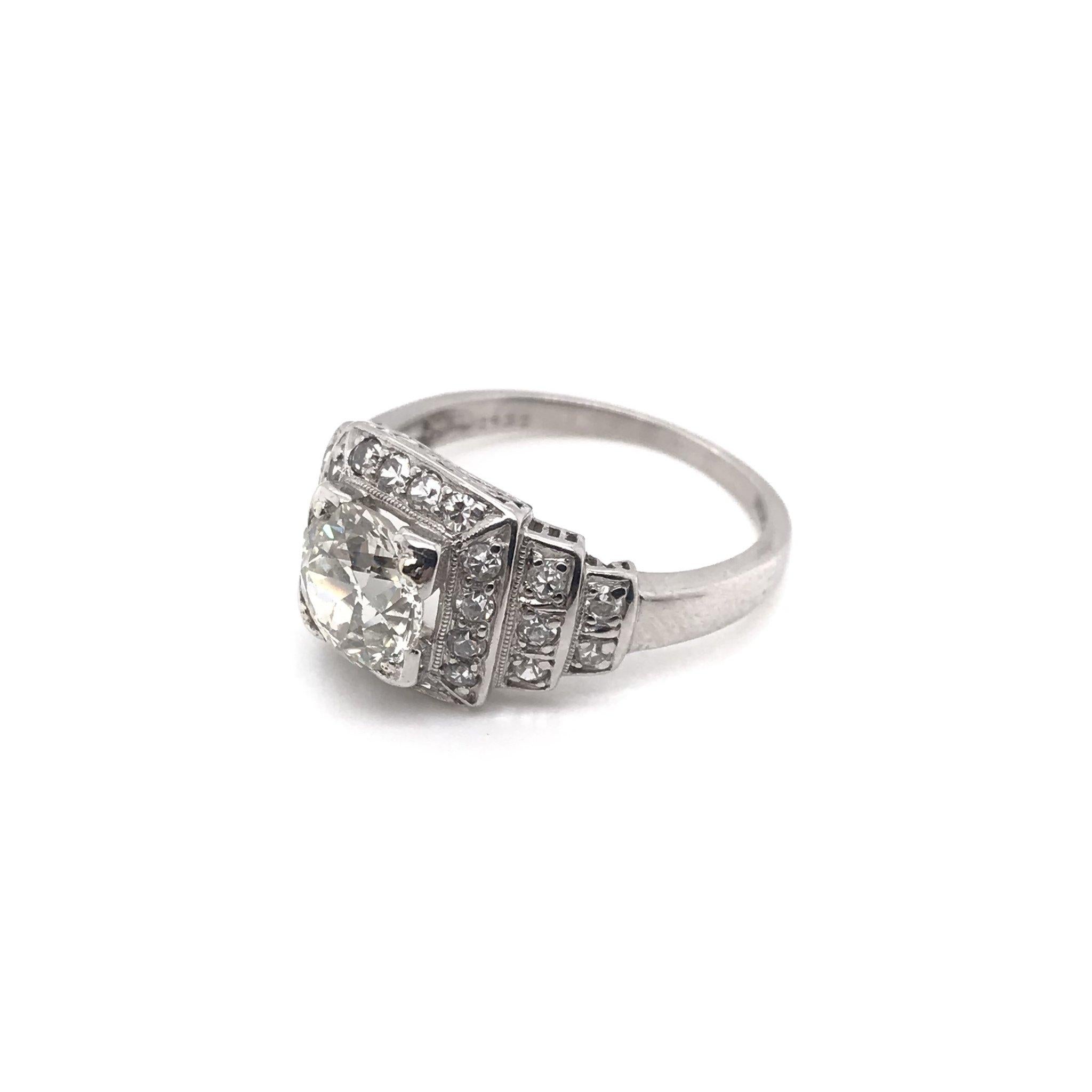 This piece was crafted sometime during the Retro design period ( 1940-1960 ). The setting is platinum and features a beautiful 1.15 carat center diamond. The center European Cut diamond grades approximately L in color, SI2 in clarity. The setting