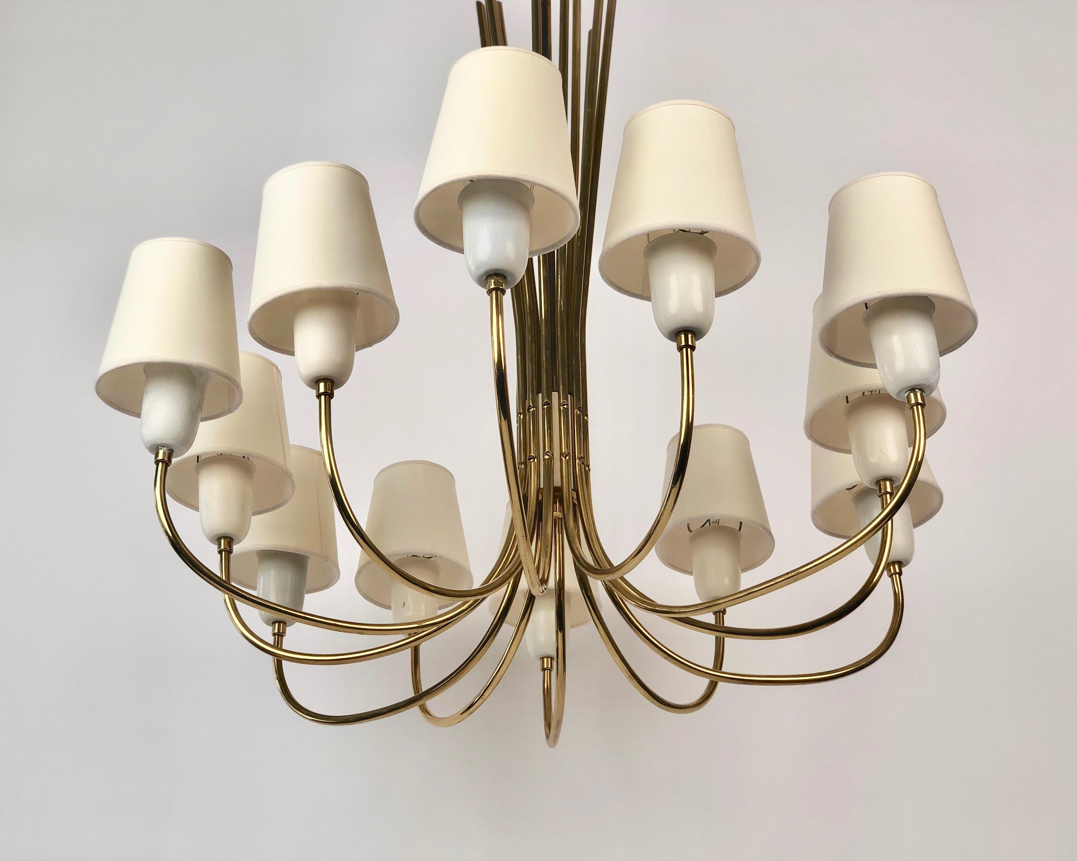 Un lampadario a 12 bracci in ottone, modello Annabelle, no. 5187 con paralumi in pergamena prodotto da J&T. Kalmar,
Vienna Austria. Secondo il catalogo la lampada è stata prodotta alla fine degli anni '50 e all'inizio degli anni '60.
Le parti in