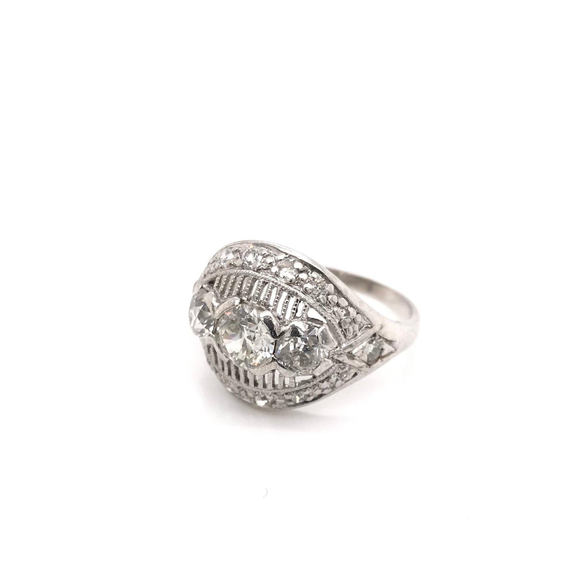 This vintage diamond ring was crafted sometime during the Mid Century design period ( 1940-1960 ). The piece features a 0.53 carat diamond in the center that grades approximately J in color, VS1 in clarity. The platinum setting features 17 diamonds