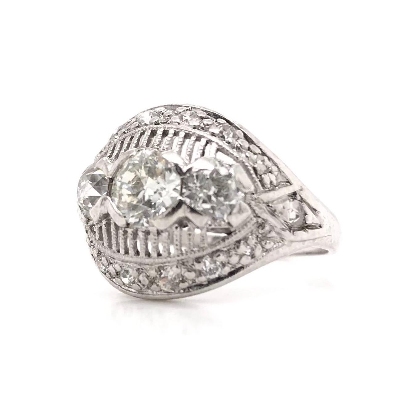 This vintage diamond ring was crafted sometime during the Mid Century design period ( 1940-1960 ). The piece features a 0.53 carat Old European Cut diamond in the center that grades approximately J in color, VS1 in clarity. The platinum setting