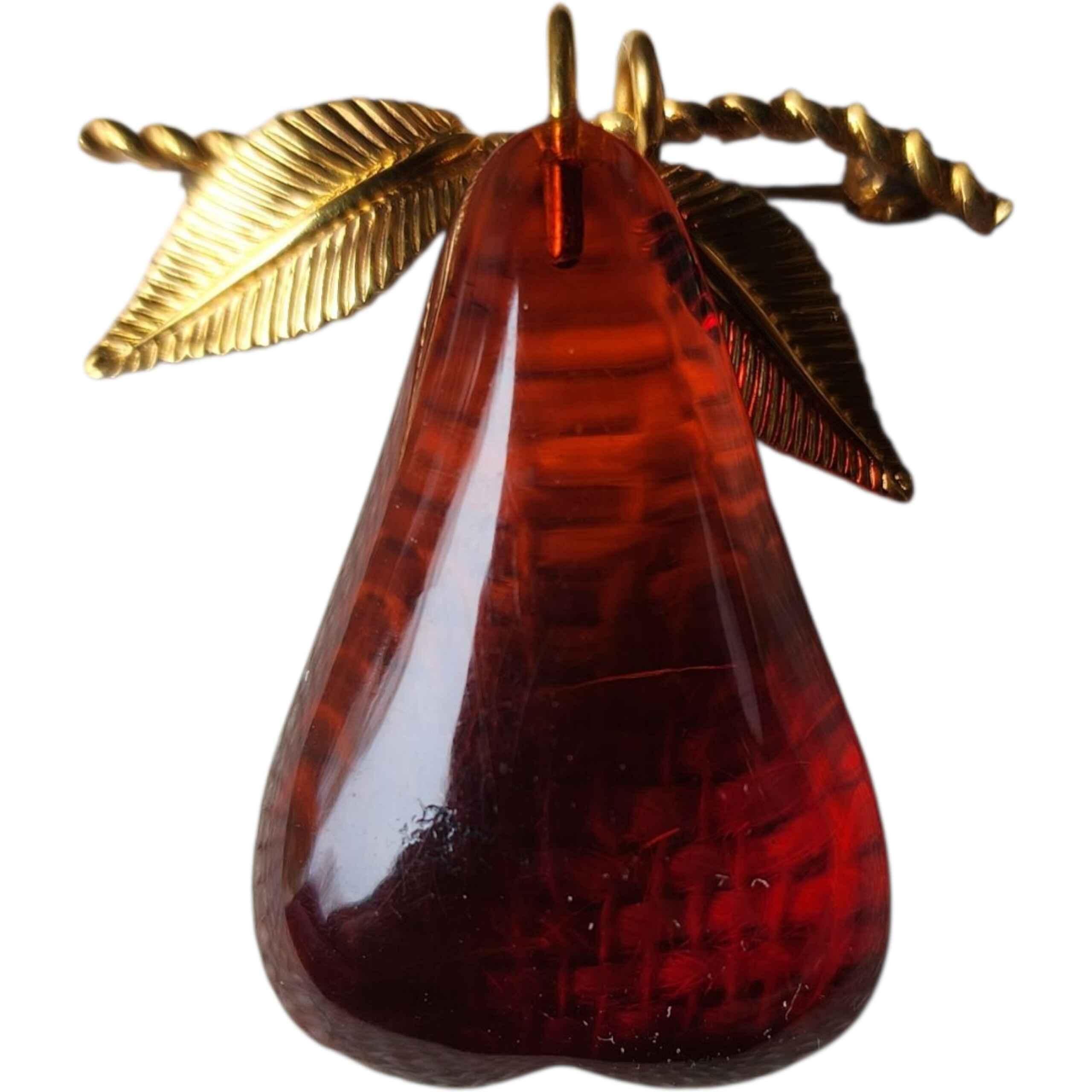 This exquisite mid-century brooch features a large, hand-carved natural Baltic amber pear set in a 12K gold-filled frame. The amber displays rich cognac-to-cherry tones with natural internal flow patterns and organic inclusions characteristic of