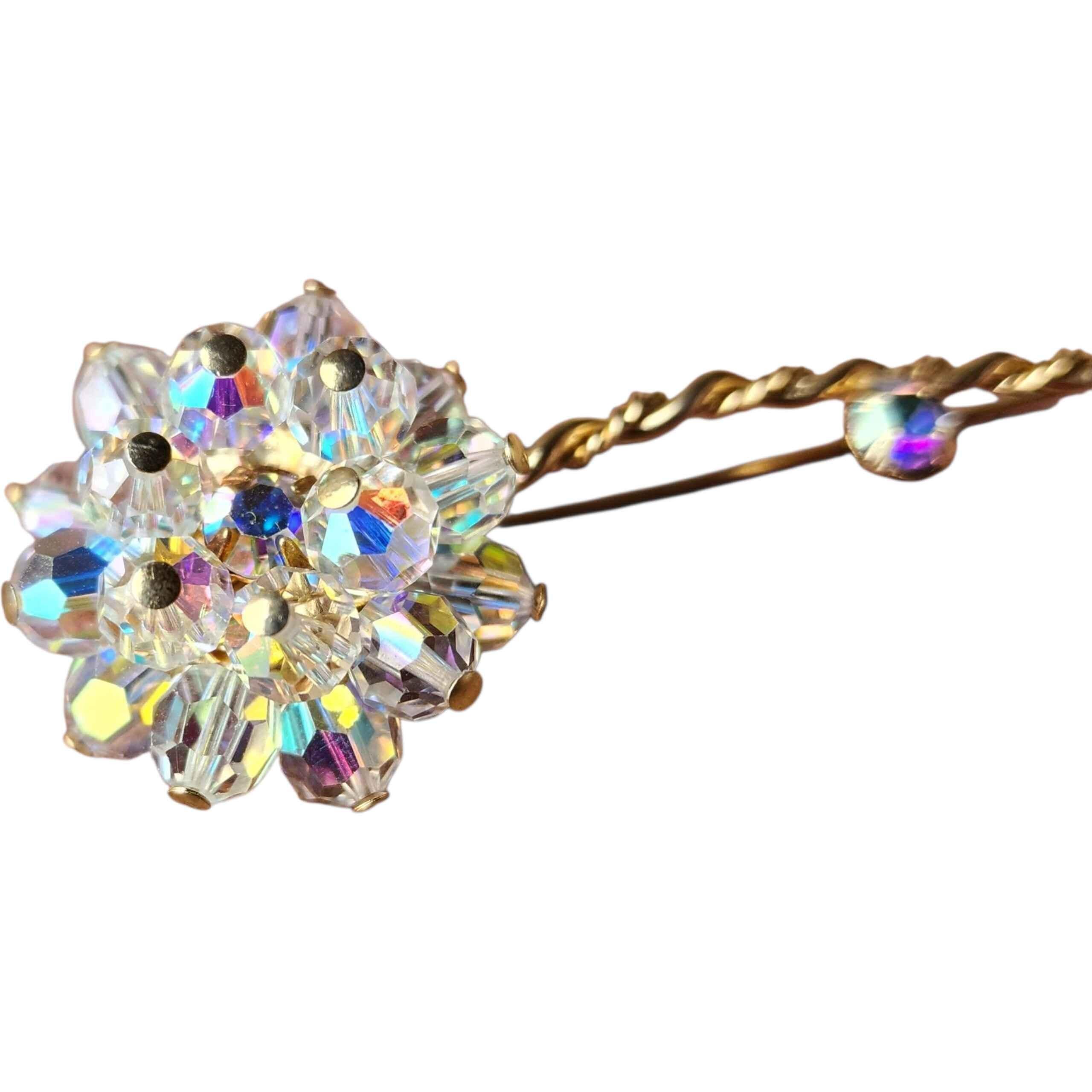 A luminous mid-century Aurora Borealis crystal flower brooch, designed with a sculptural cluster of faceted AB crystals that catch the light in iridescent flashes of blue, violet, gold and rose. Each crystal petal is securely prong-set, forming a