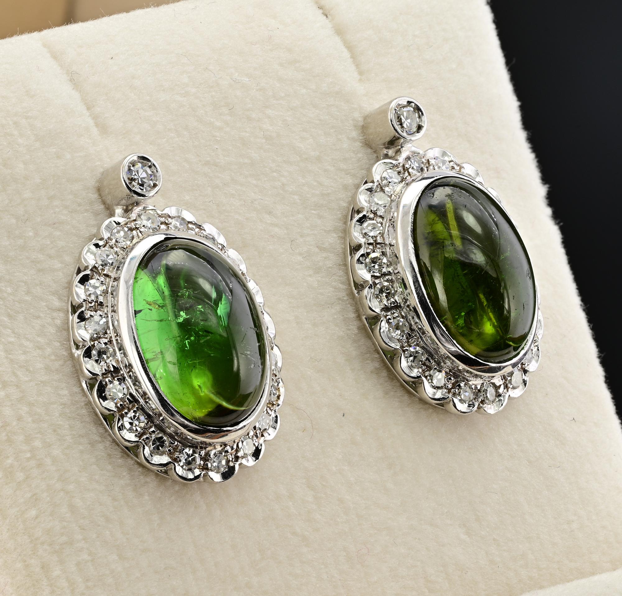 These beautiful mid-century earrings are 1950 circa, hand crafted of solid 18 KT white gold
Charming classy design exalting the oval shape gem set consisting of two natural Green Tourmaline cabochon cut 13.0 Ct for both (13 mm. x 9.14 mm.)  pleasing