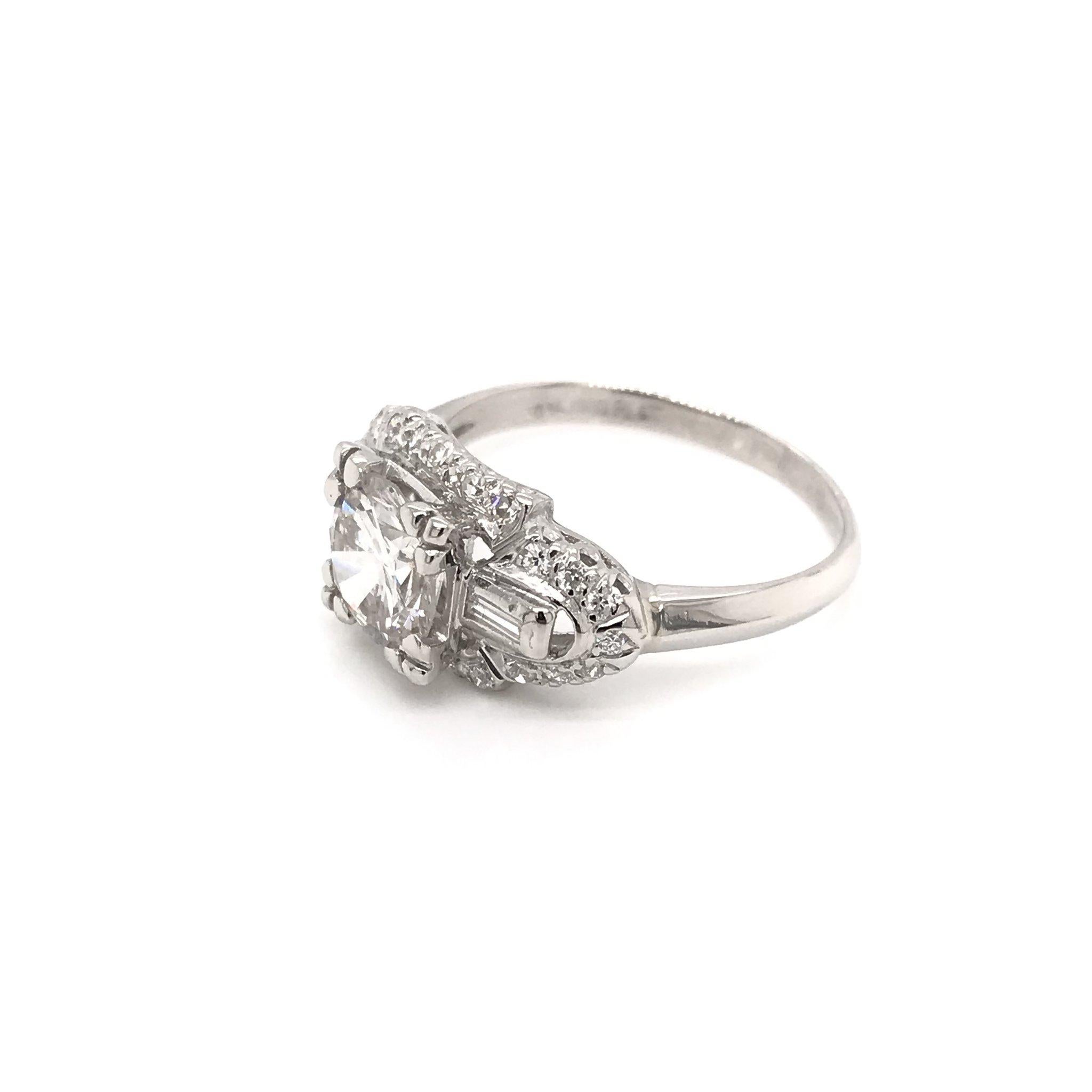 This beautiful Mid Century piece was crafted sometime during the Retro design era ( 1940-1960 ). The setting is platinum and features a center diamond measuring approximately 1.32 carats. The center diamond grades approximately I in color, SI1 in