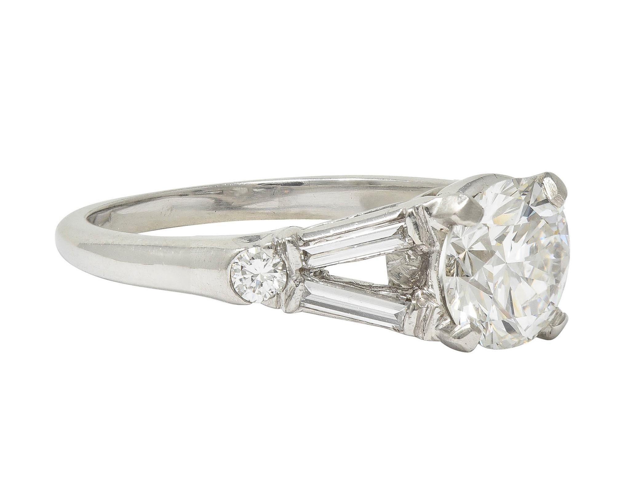 Centrado en un diamante de talla de transición de 0,99 quilates - color F con claridad SI1
Engastado en cesta y flanqueado por hombros partidos estilo catedral 
Barra y garras engastadas con diamantes talla baguette y de transición
Con un peso total