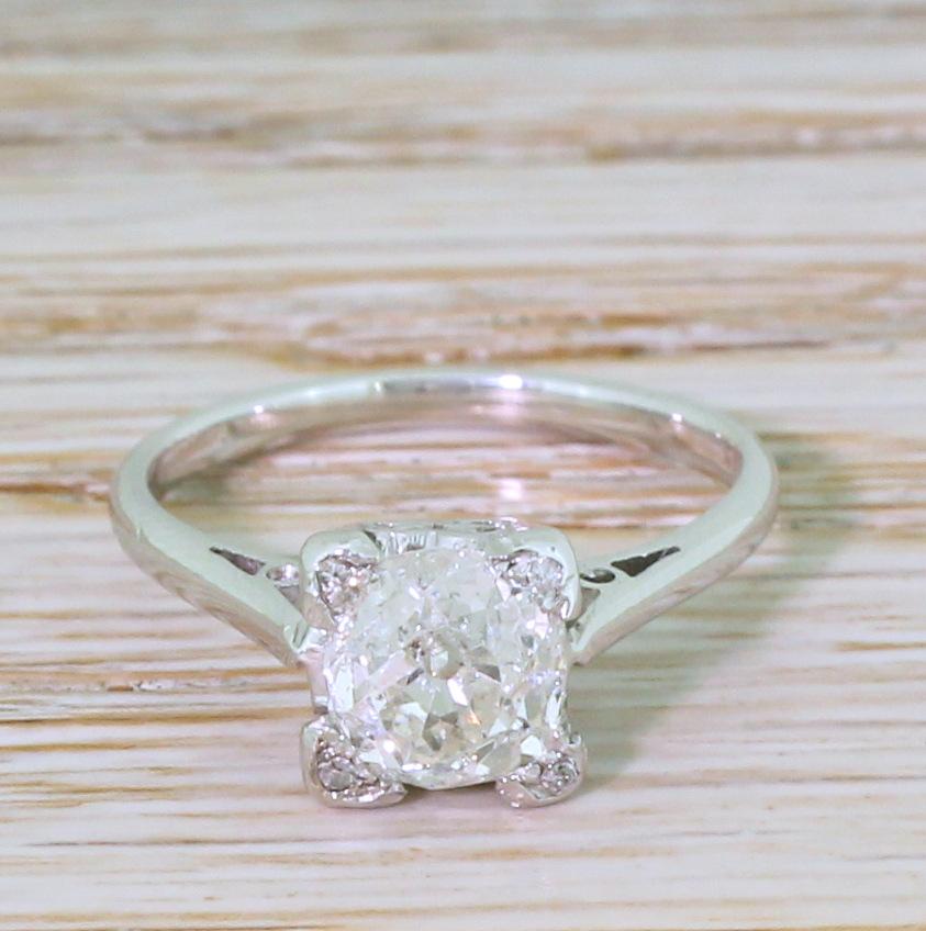 An exceptionally pretty and unique vintage diamond solitaire. The old mine cut diamond in the centre is high white, bright and very, very lively. The stone is secured in a square collet with each of the corner claws holding a small eight-cut