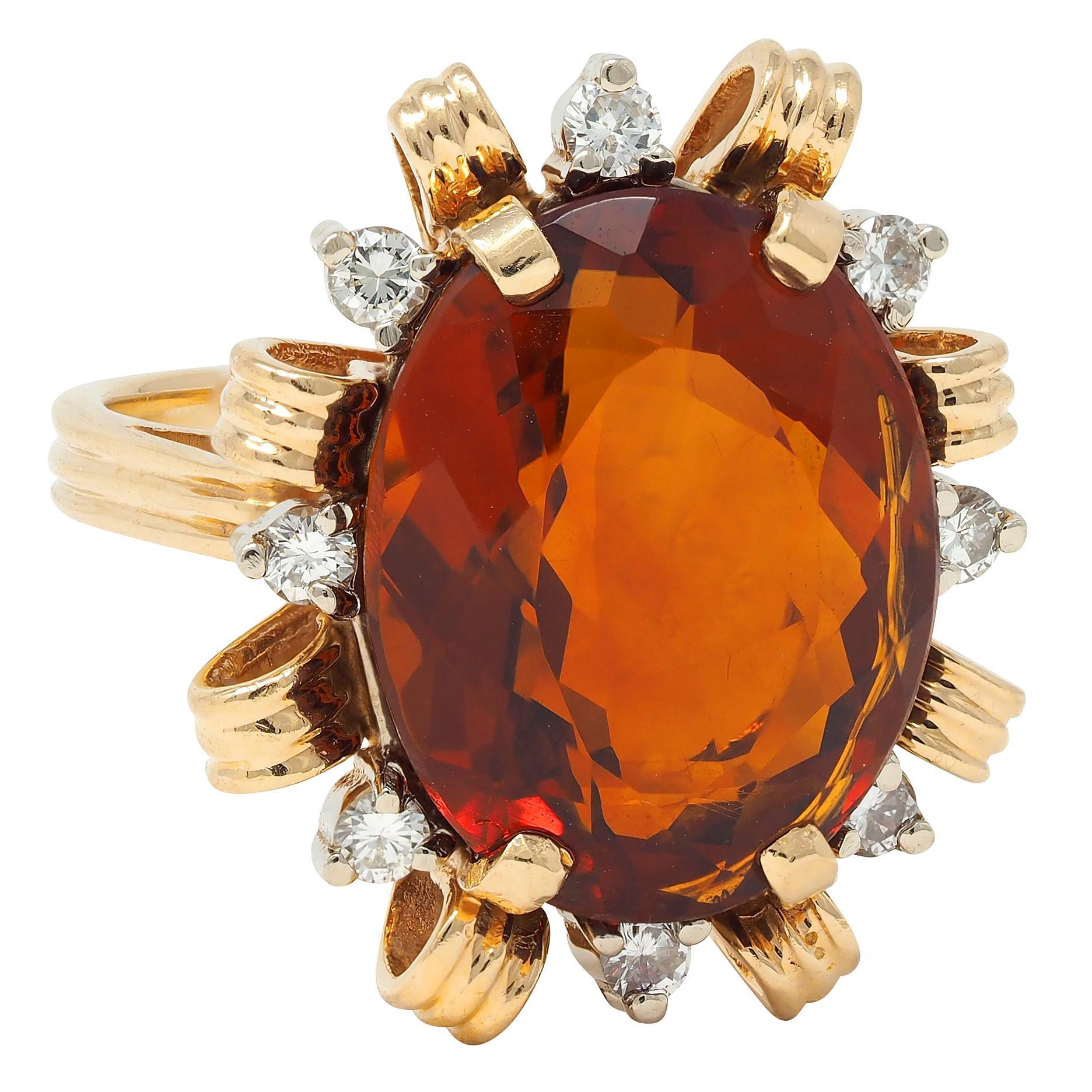 Al centro un citrino misto taglio ovale del peso di circa 13,35 carati 
Colore arancione rossastro medio trasparente - incastonatura a griffe
Con un'aureola circondata da diamanti rotondi taglio brillante
Peso totale di circa 0,40 carati - colore