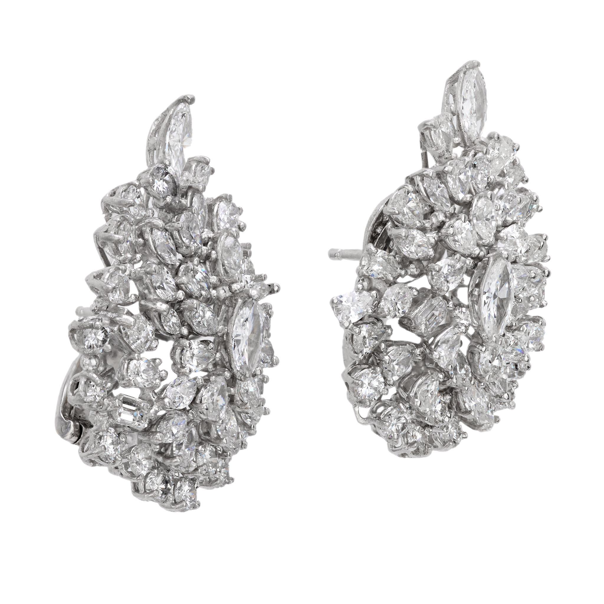These bold Mid Century cluster earrings shimmer with 90 marquise, pear, and emerald cut diamonds totaling 14 carats. Set in 18k white gold, they radiate glamorous 1960s elegance and exceptional brilliance.