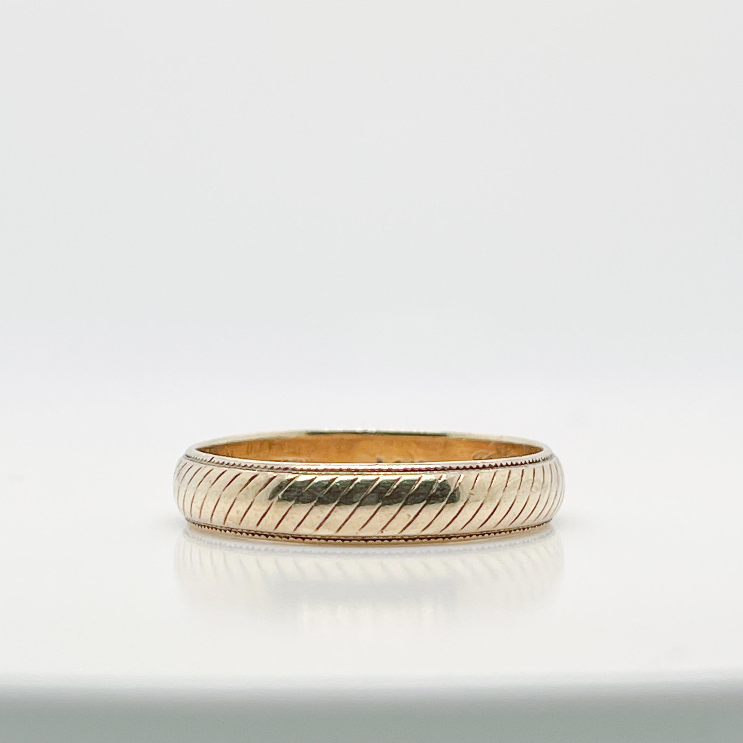 A very fine wedding band or ring.

By Tiffany & Co.

In 14k yellow gold. 

With engraved diagonal lines around the circumference of the large half round band.

Simply a wonderful ring by Tiffany & Co.!

Date:
20th Century

Overall Condition:
It is