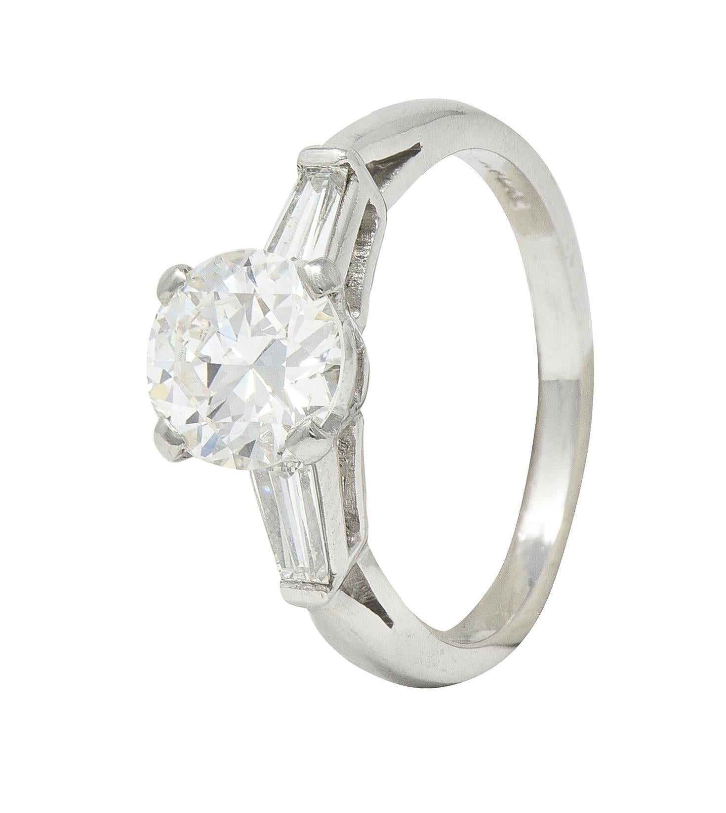 Ring centers a prong set round transitional cut diamond weighing 1.15 carat total - I color with SI2 clarity
Flanked by cathedral shoulders bar set with tapered baguette cut diamonds
Weighing approximately 0.30 carat total - I color with SI2
