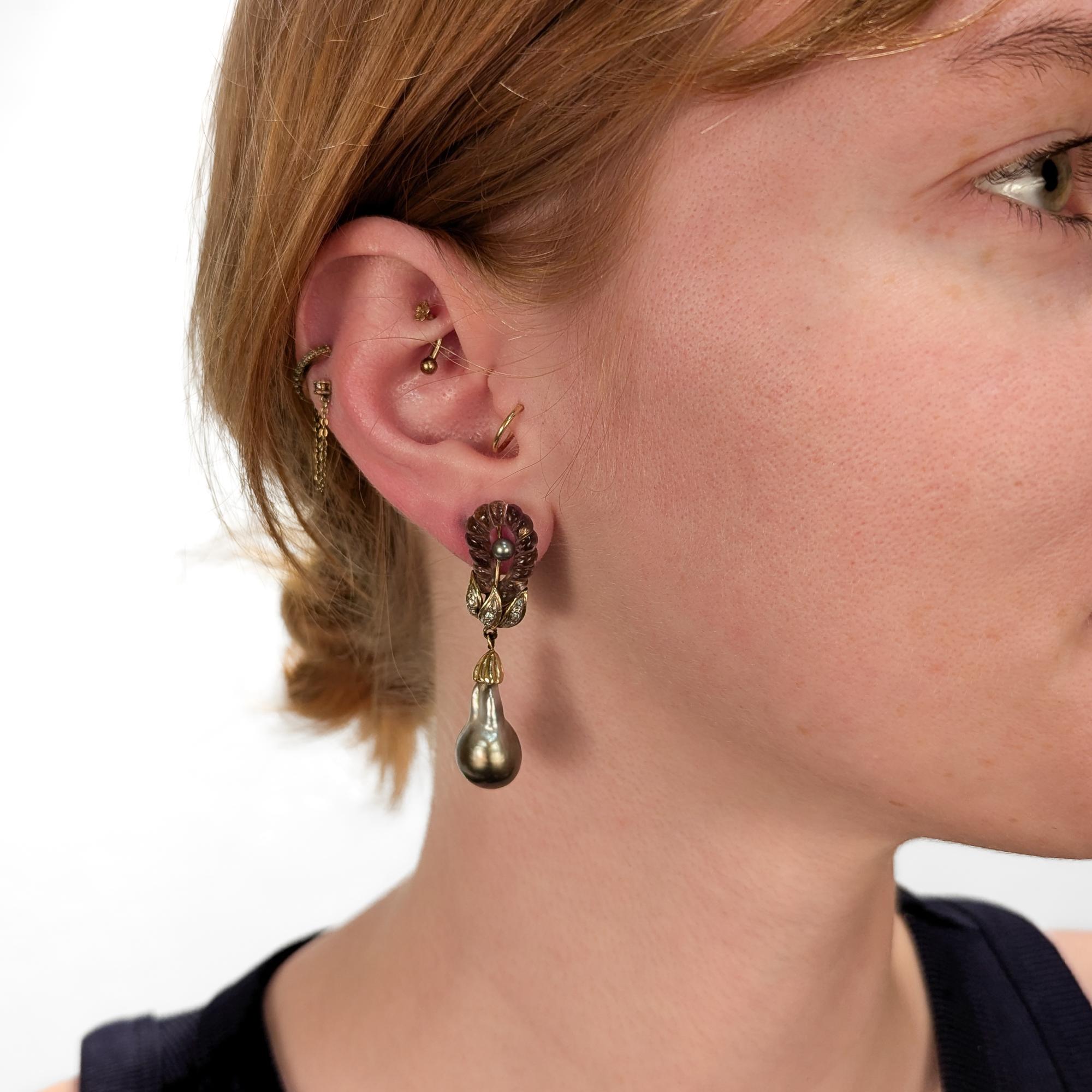 Paire de boucles d'oreilles en or, améthyste et perles baroques du milieu du siècle dernier.

En or jaune 14 carats.

Les têtes floriformes sont ornées de pierres d'améthyste sculptées, les étamines de perles grises et les feuilles sont serties de