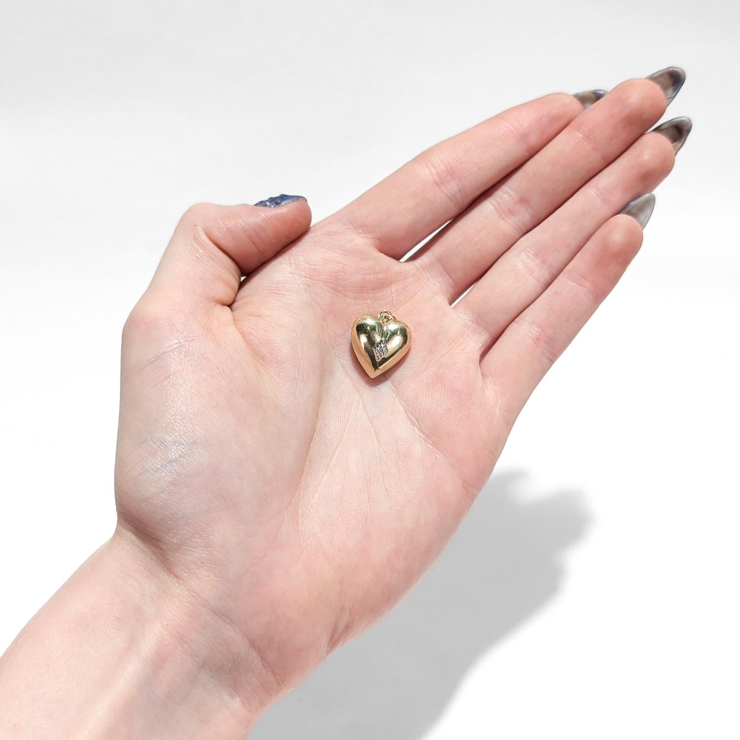 Ein feiner figuraler Gold-Charme aus der Mitte des Jahrhunderts.

Aus 14 Karat Gelbgold.

In Form eines goldenen Herzens mit einem zentralen, in Zacken gefassten, rund geschliffenen Diamanten innerhalb einer diamantförmigen Kartusche.

Mit einem
