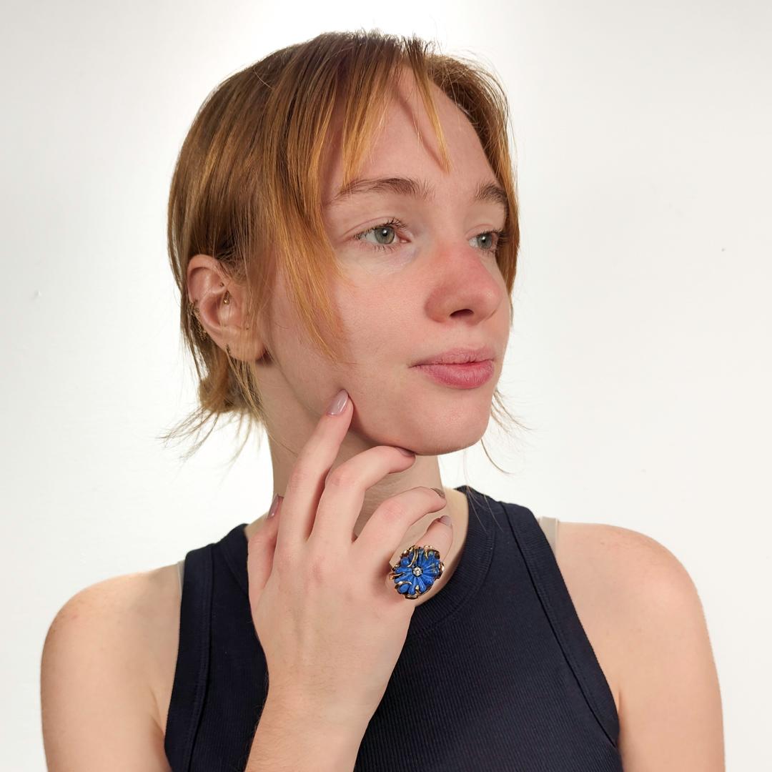A fine Mid-Century cocktail ring.

In 14 karat gold.

Featuring a large lapis lazuli cabochon carved in the shape of a flower center-set with a round brilliant-cut white diamond and set in a handmade, flowing mounting of stylized vines.

Simply a