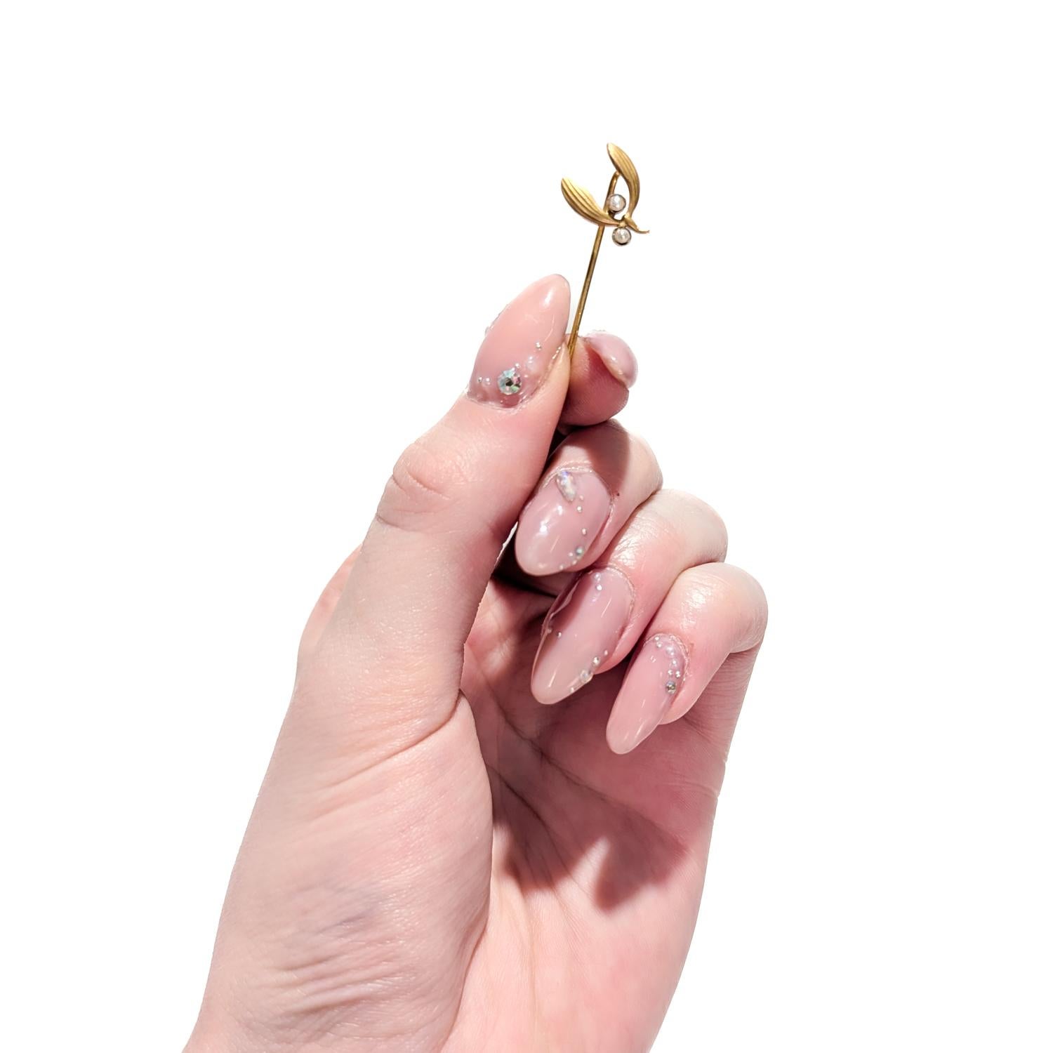 A fine vintage stickpin.

In 14 karat yellow gold.

In the form of a sprig of mistletoe with leaves and two bezel-set pearls as its white berries.

Marked 14k to the pin stem for gold fineness.

Simply a wonderful stickpin!

Date:
20th