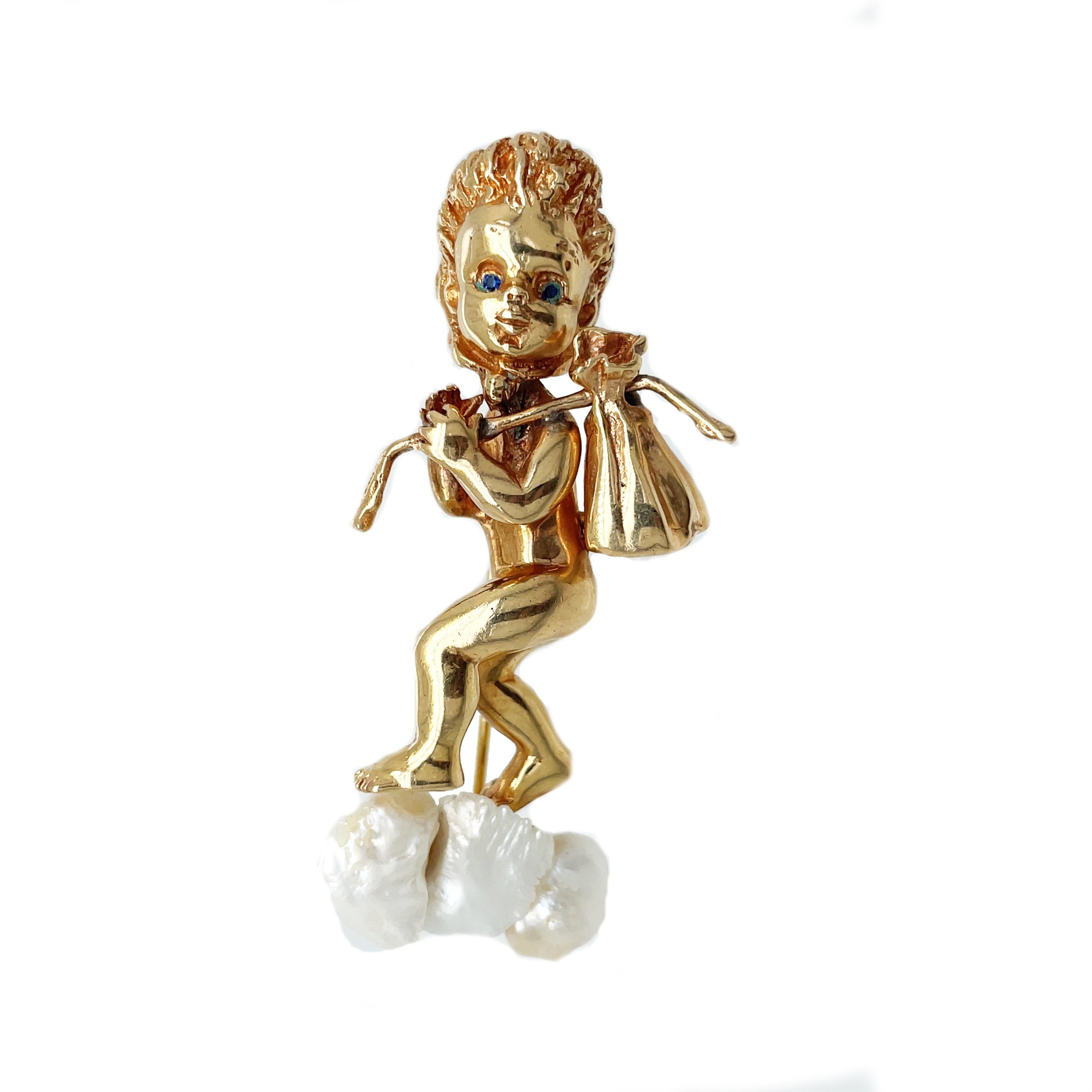 This is an amazing signed Ruser pin set in 14K yellow gold that features three Mississippi Delta Pearls and vivid blue sapphire eyes! This unique, clever, and whimsical piece depicts a cute little blue-eyed child carrying a bag over their shoulder.