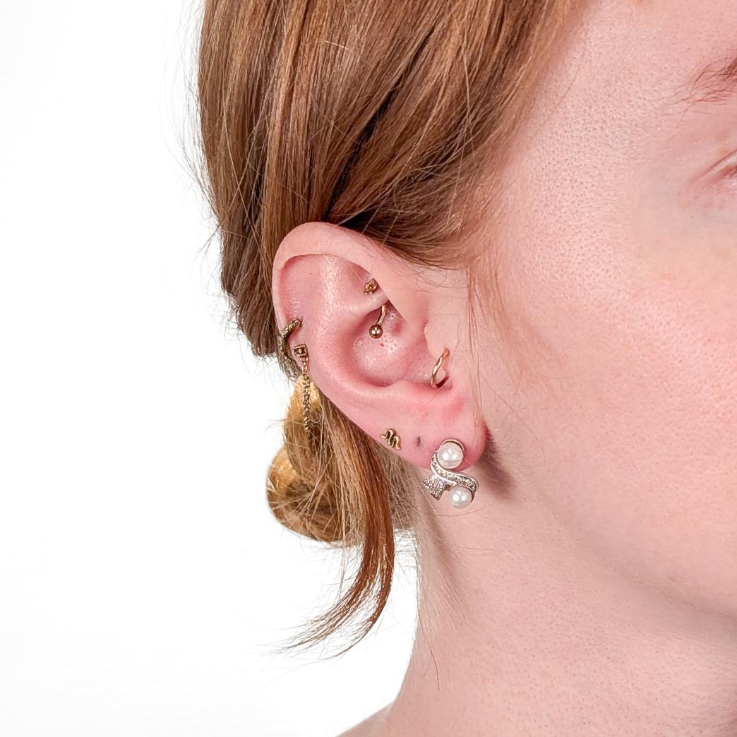 A fine pair of white gold, pearl, and diamond stud earrings.

In 14 karat white gold.

Each earring with 2 round white pearls with slight cream overtones and 12 single cut round diamonds.

Marked to the push backs of each.

Simply a wonderful pair