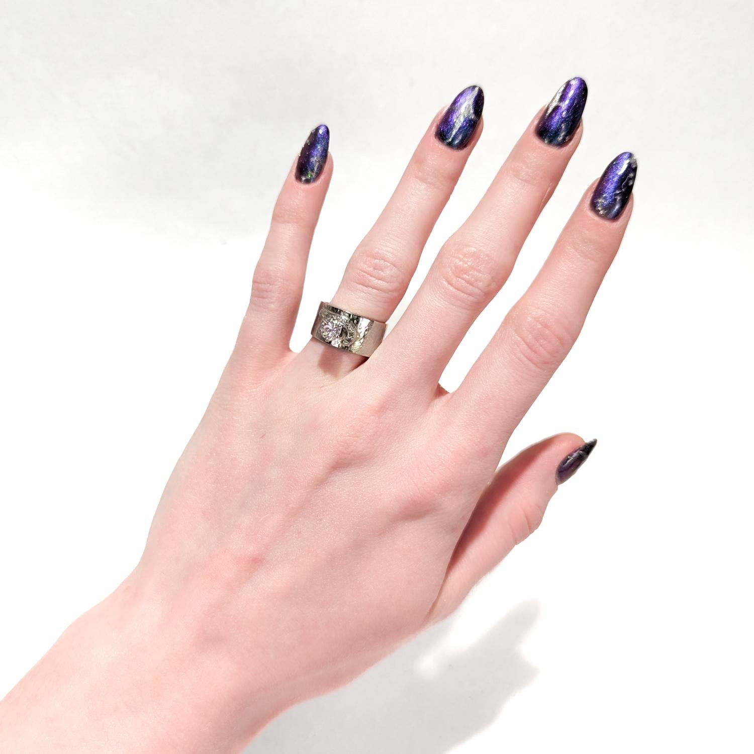 Bague de cocktail vintage en or blanc et diamants.

En or blanc 14 carats martelé à la main avec un large bracelet.

Serti d'un diamant rond de taille brillant d'environ 0,68 ct.  (couleur G-H, clarté VS). Autour de la base du diamant principal se