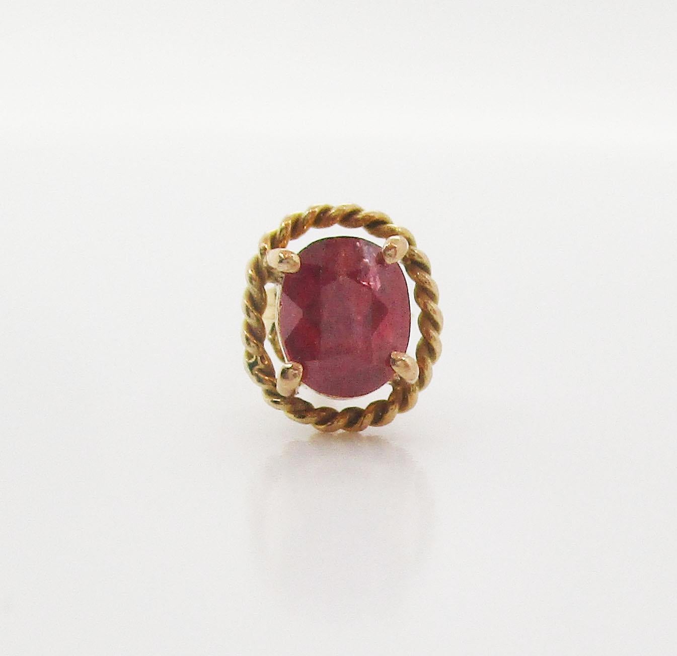 This is a beautiful pair of mid-century stud earrings in 14k yellow gold featuring bright red ruby centers! The rubies are a classic oval shape in a four-prong setting that is surrounded by a twist wire frame with an element of negative space